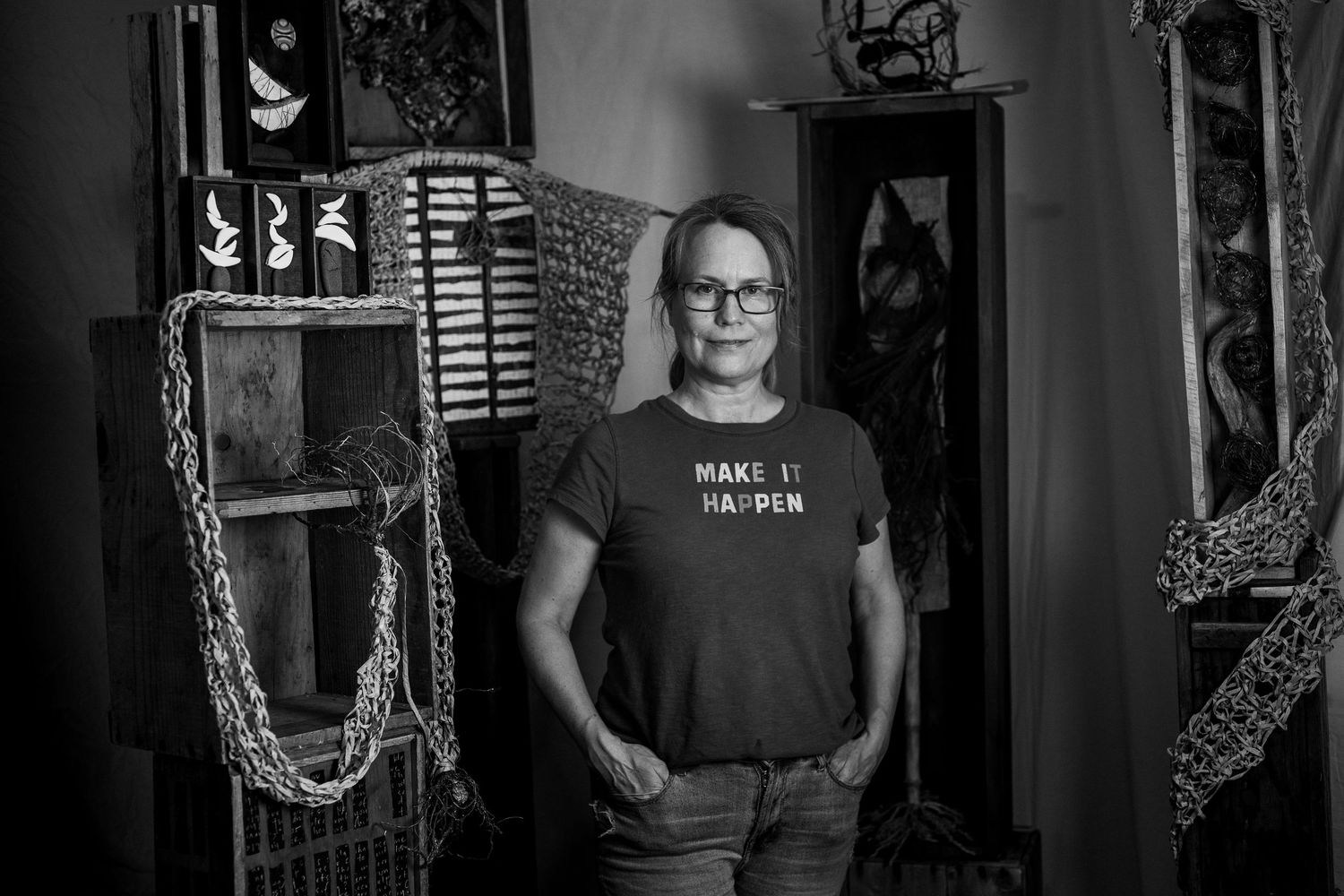 A series of five black and white photographs showing someone in a dark room with ornate decorative frames on the wall.
