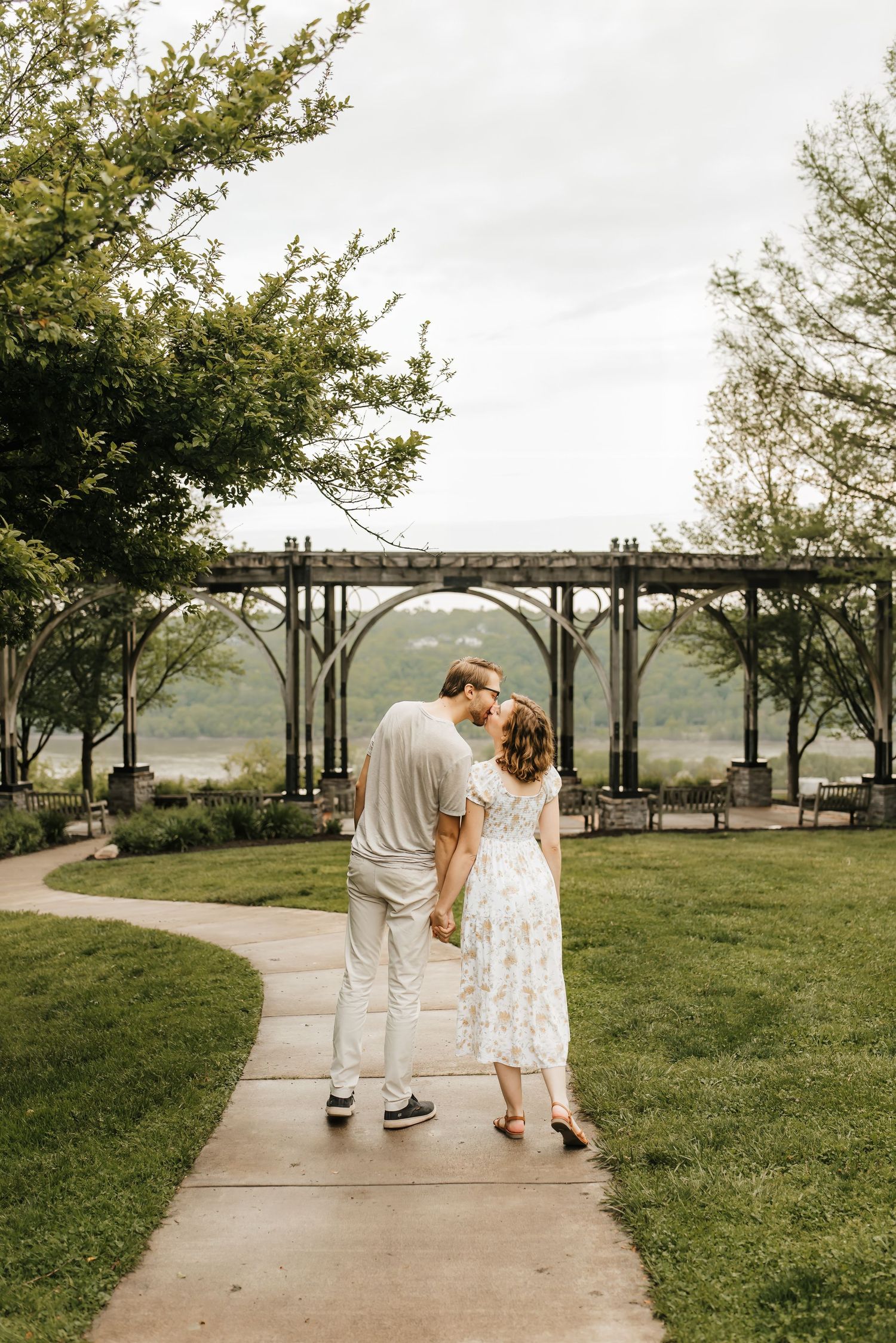 Couple kisses as they walk along the ohio river.