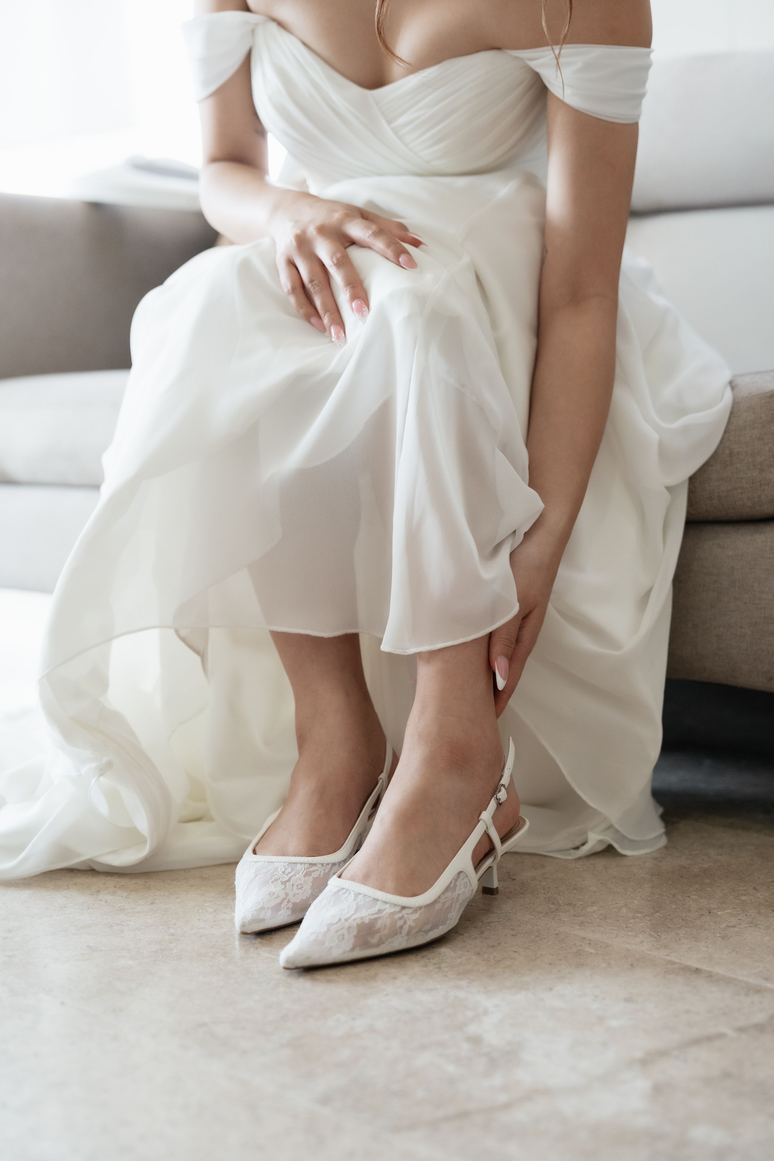 Bride putting on her wedding shoes during getting ready before the ceremony at a Riviera Maya destination wedding.