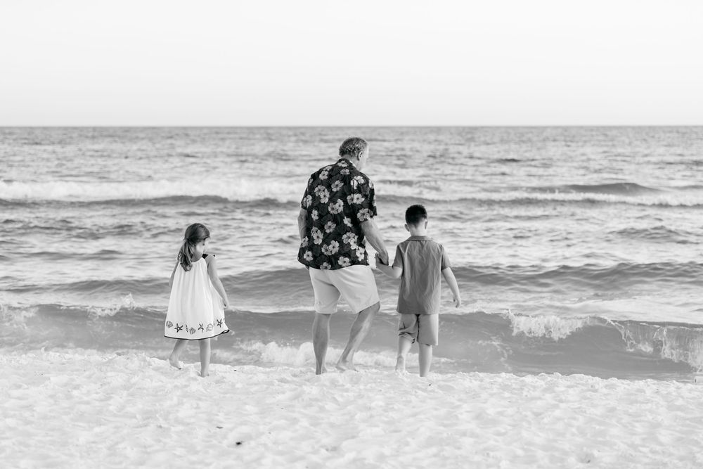 A series of black and white photographs showing people walking and playing along a beach shoreline.