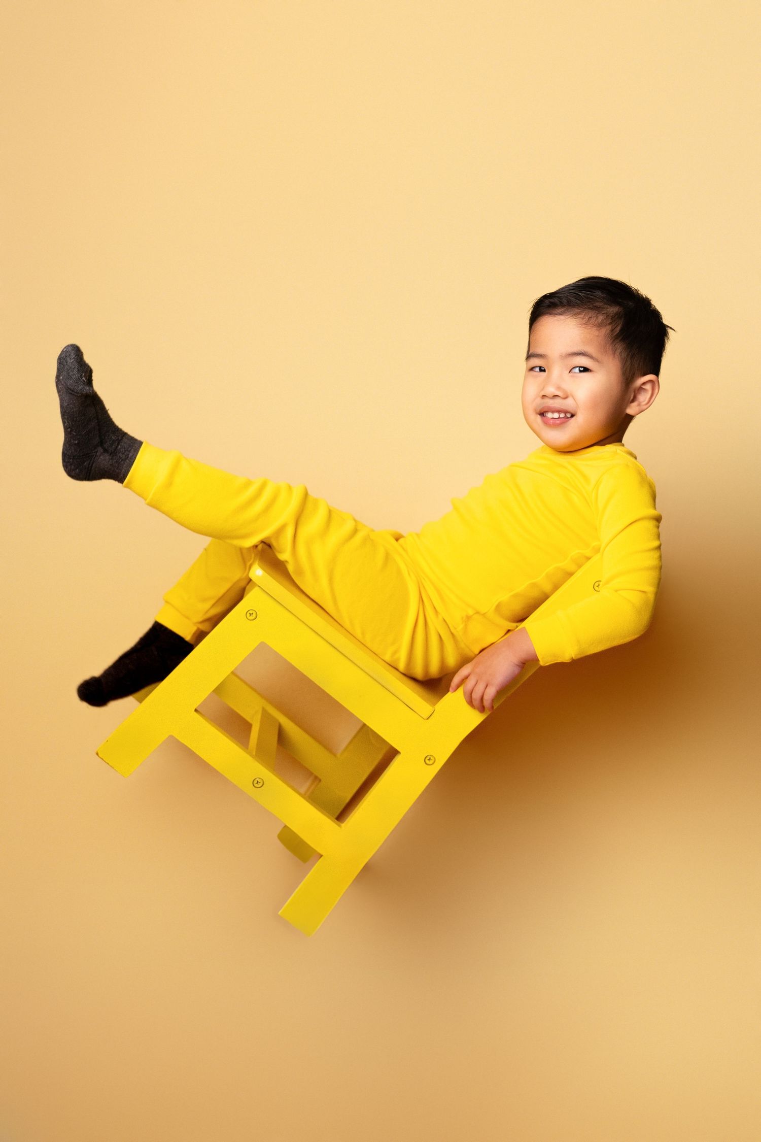 Dynamic sequence of a person in bright yellow clothing appearing to float against a yellow backdrop.