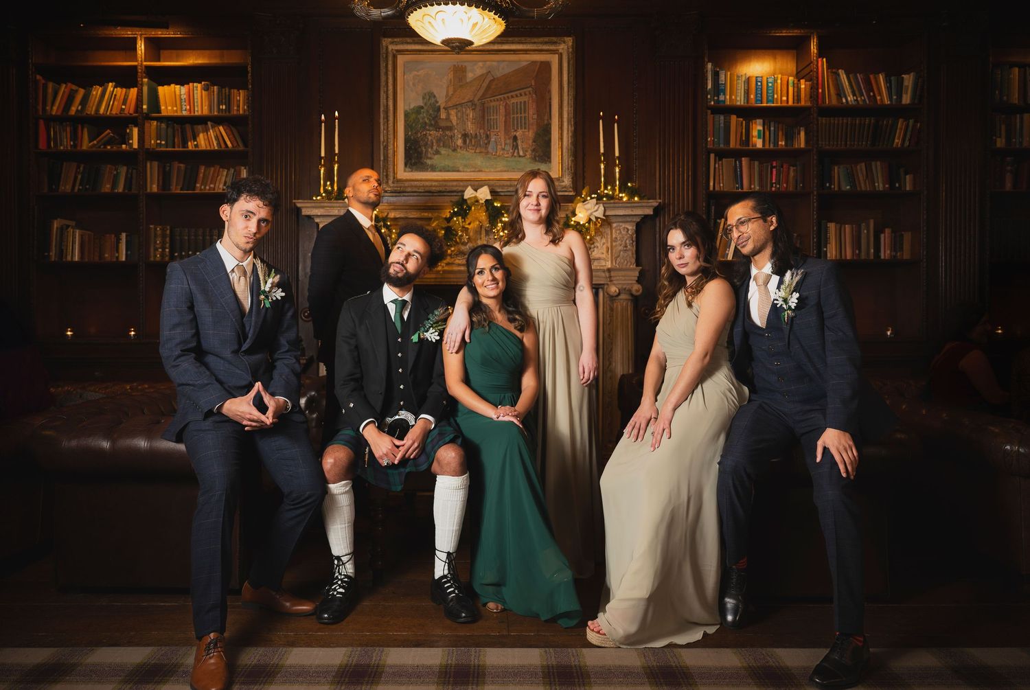 Wedding party dancing and celebrating in an elegant wood-paneled library with warm lighting and bookshelves.
