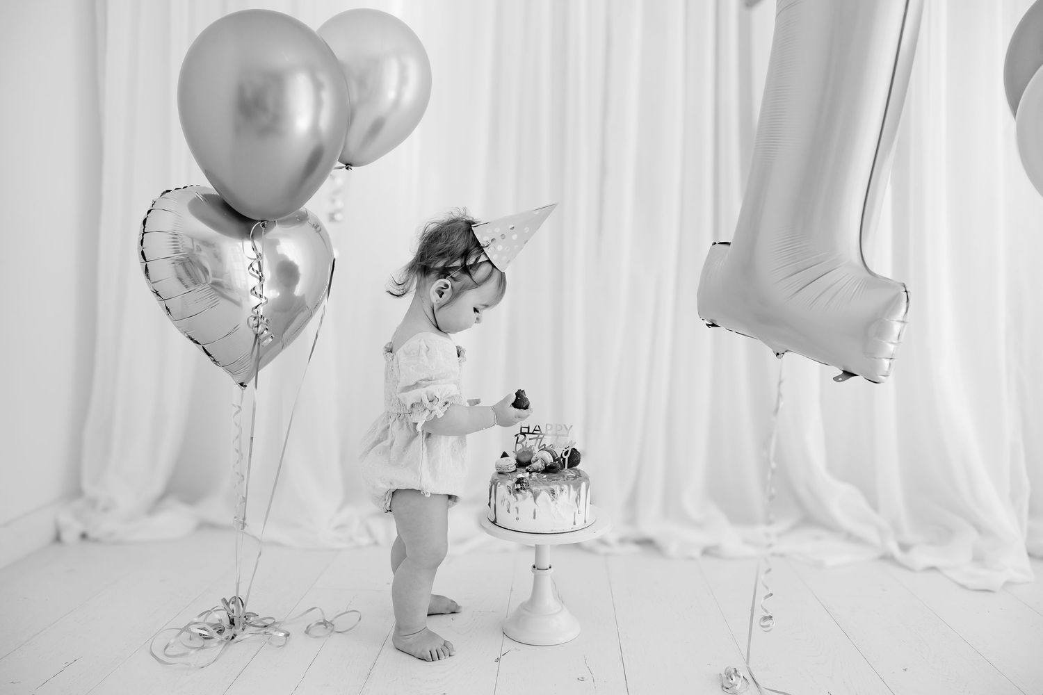 A joyful family moment captured in black and white as they sit together in a sunlit field.