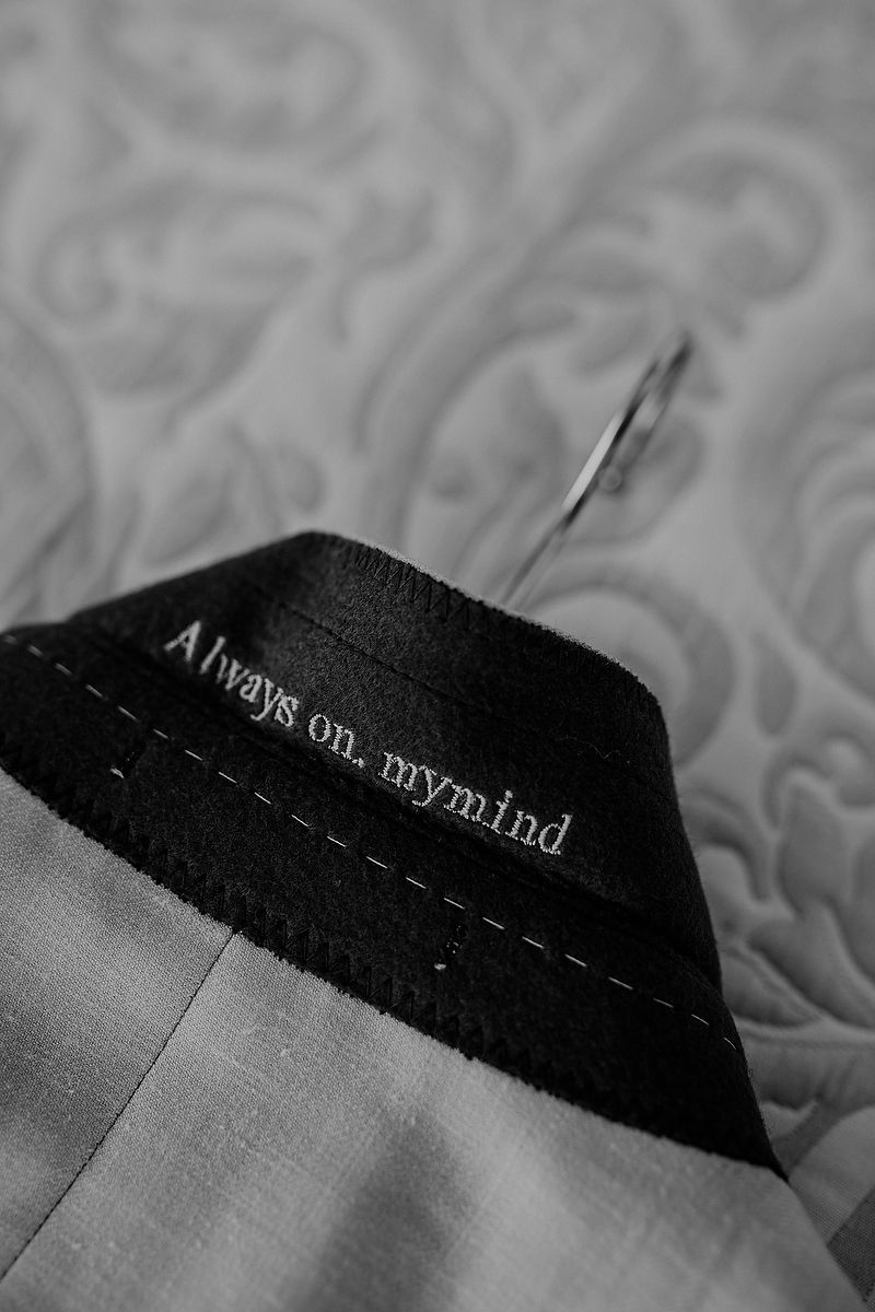 Close-up view of black and white stitching detail on fabric with text visible.