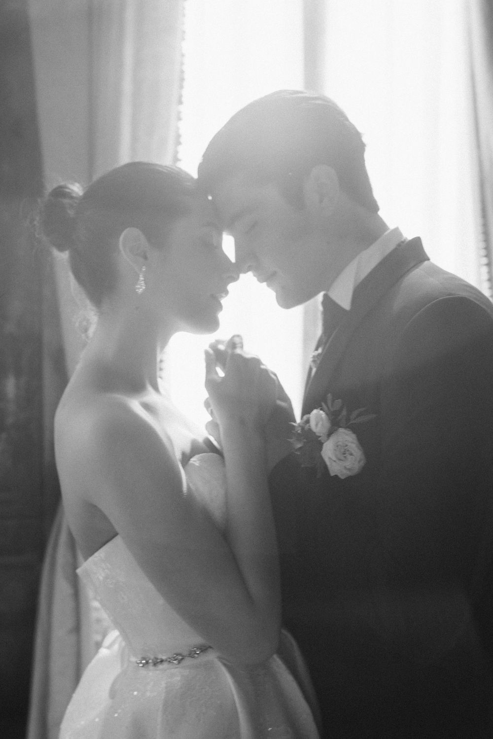 A romantic black and white wedding photo series showing intimate moments between a couple in formal attire.