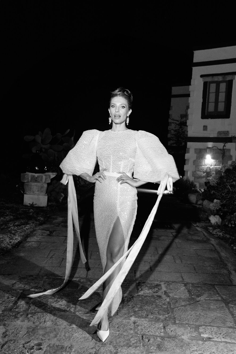 A black and white photo series shows someone in a white dress dancing and twirling in a dark outdoor setting. Puglia wedding photographer