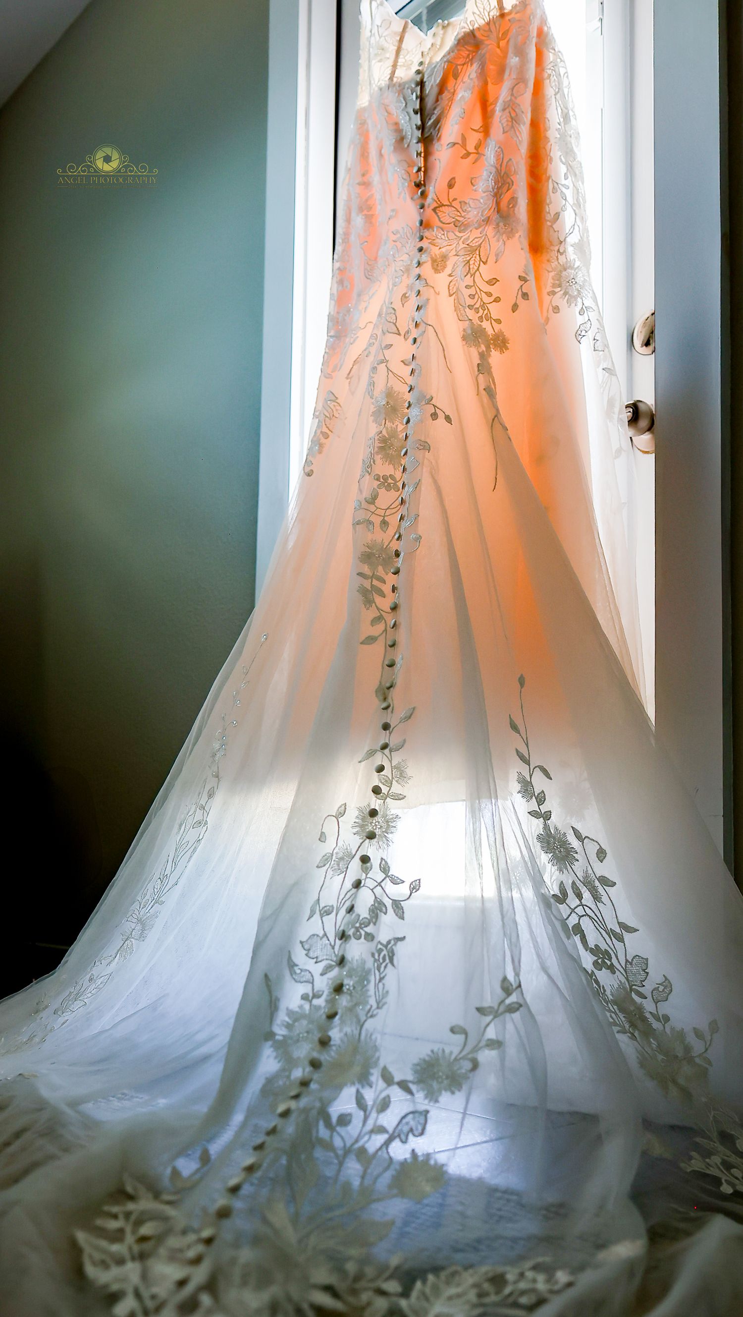 White wedding shoes next to red and blue floral decorations with a sparkling engagement ring on display.