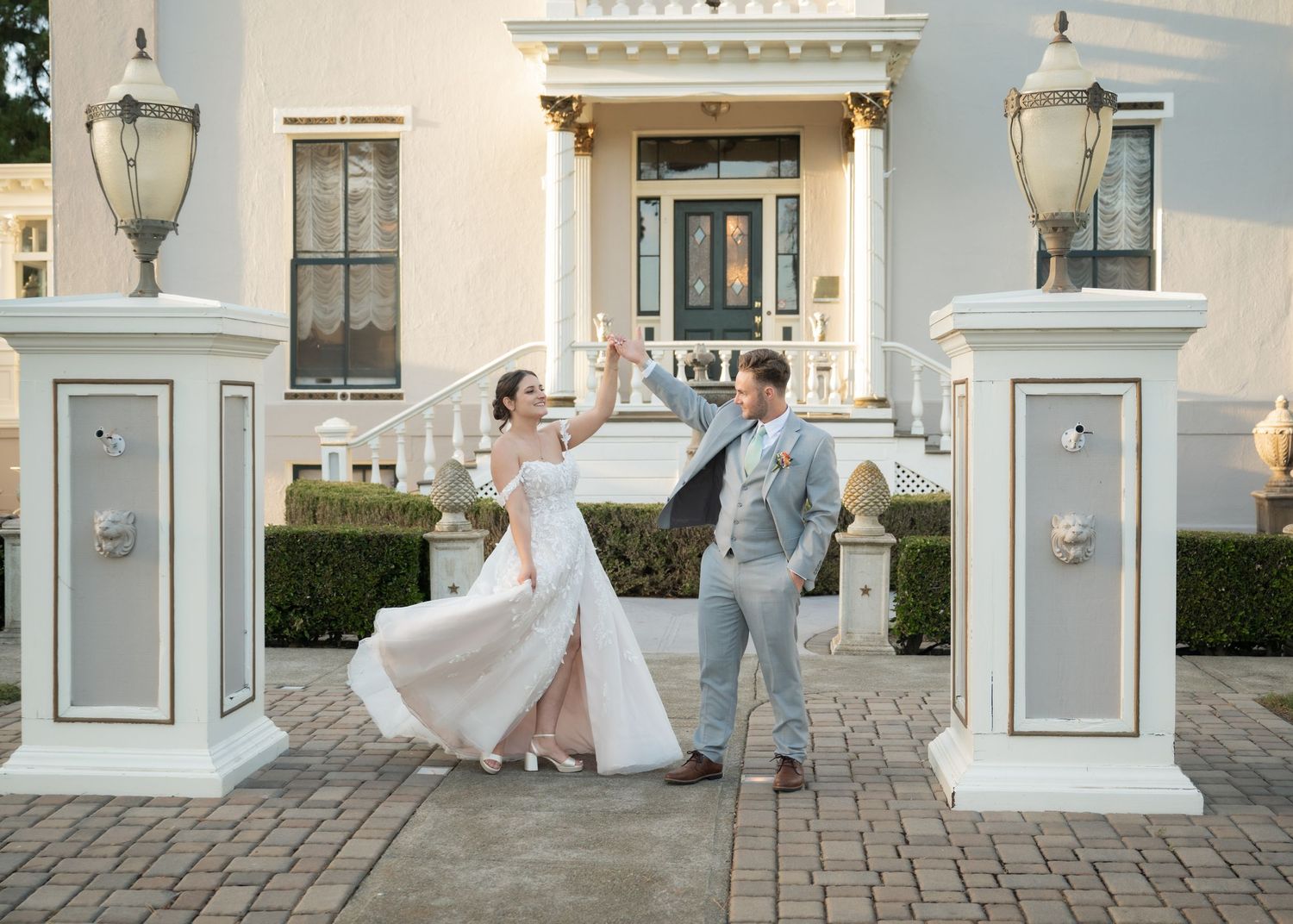 A bride and groom dance and twirl in front of a historic San Francisco Bay Area estate with their northern California wedding photographer