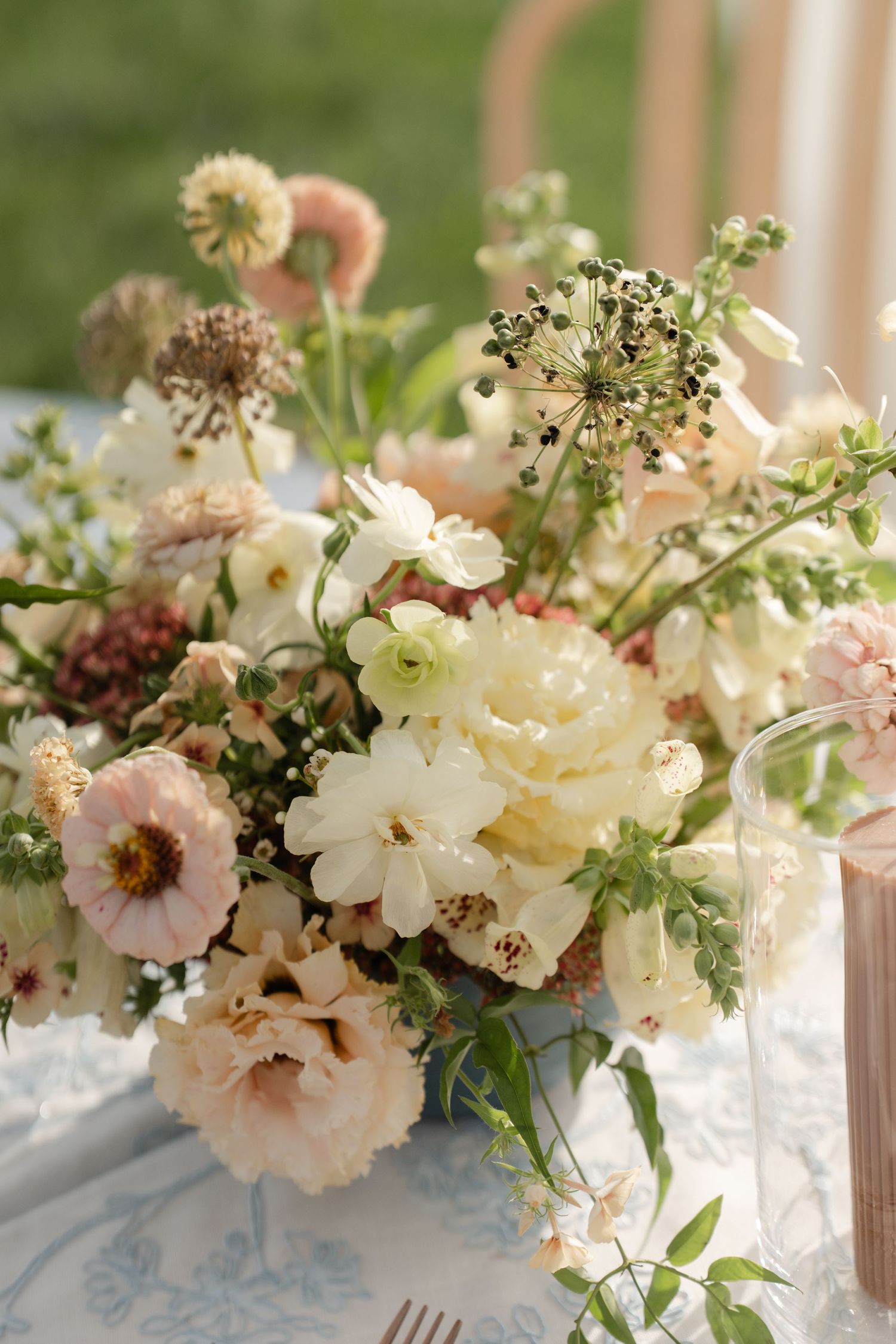 Elegant floral centerpiece with cream and blush flowers arranged in a romantic garden style.