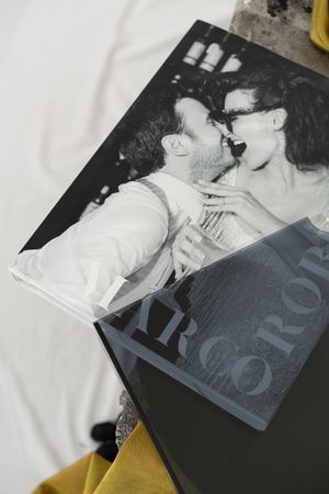 Black and white photography book pages showing intimate romantic scenes with artistic typography overlay.