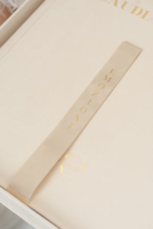 Series of minimalist cream-colored book spines with elegant gold lettering arranged in a row.