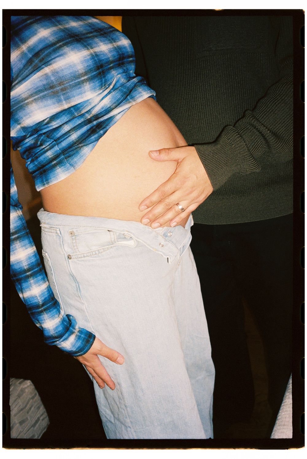 Husband holds his pregnant wife's belly lovingly during a maternity photoshoot on 35mm film at a hotel in Kennebunkport, Maine.