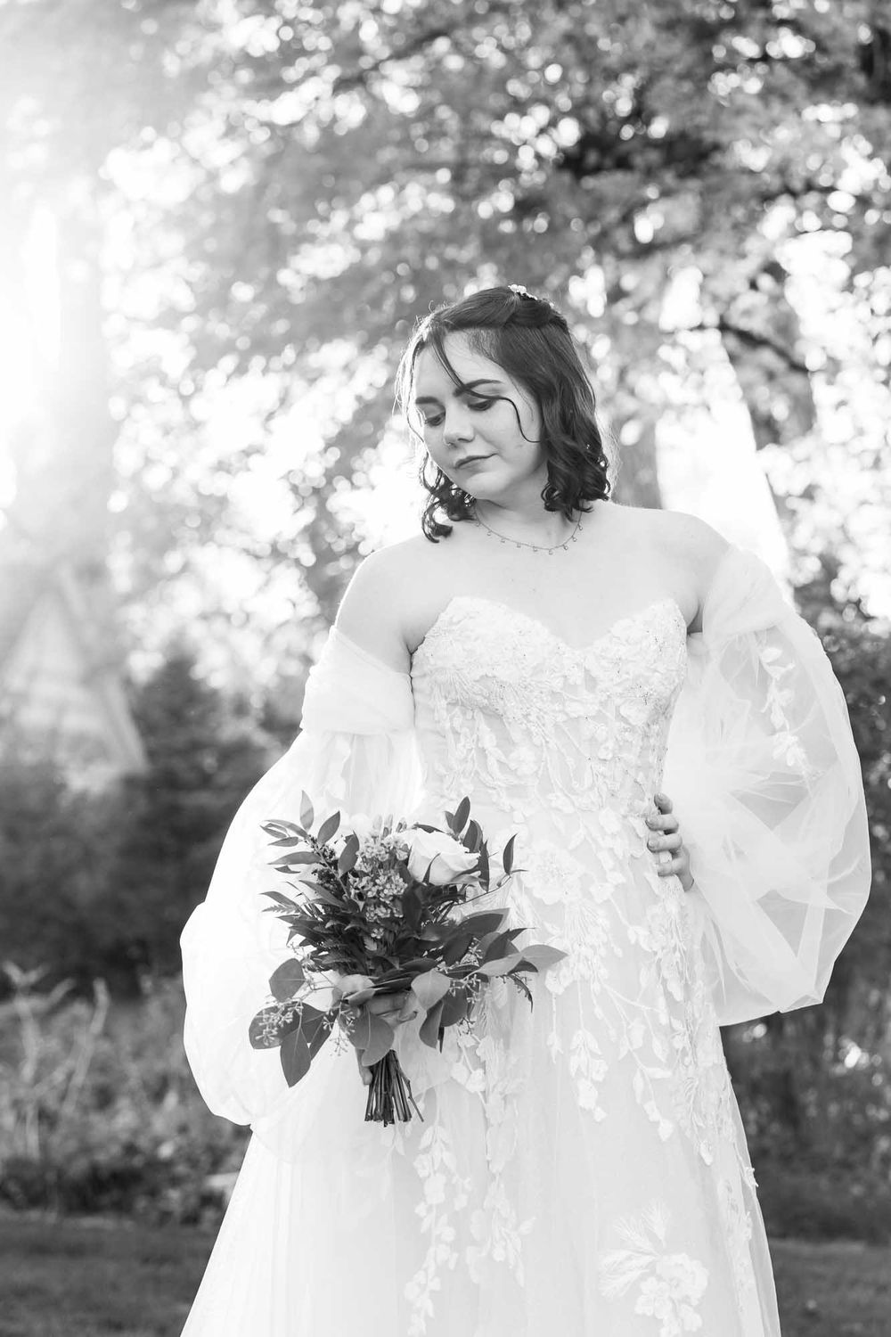 Elegant lace wedding dress details shown in soft black and white photography.