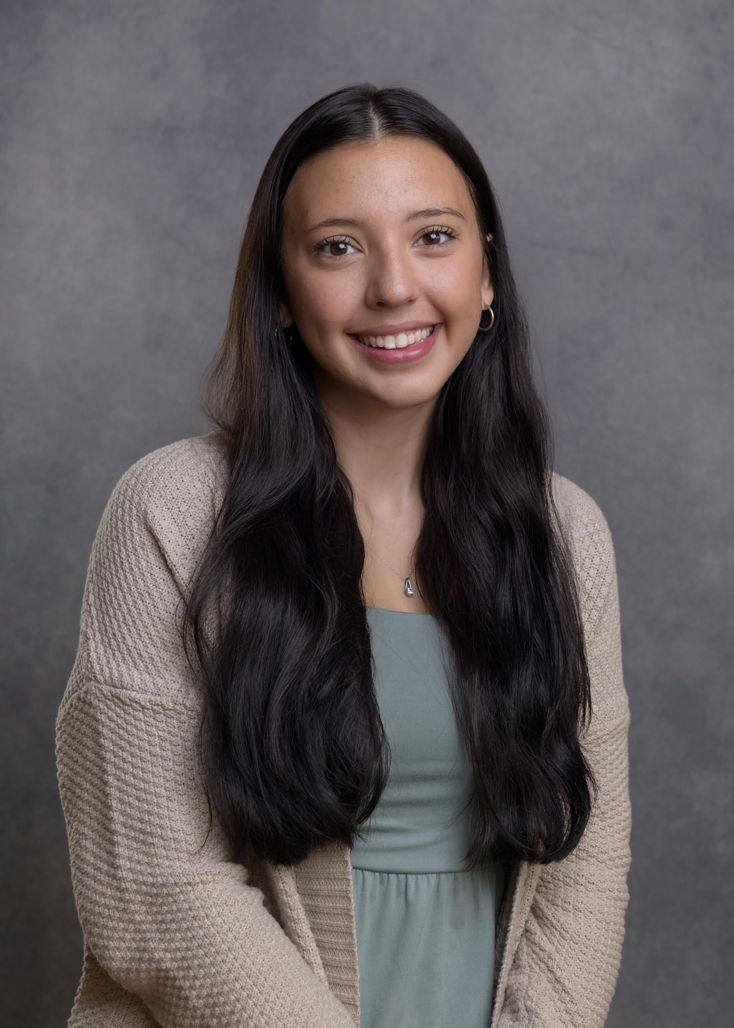 Studio portrait series showing different expressions while wearing a beige sweater and mint green top.