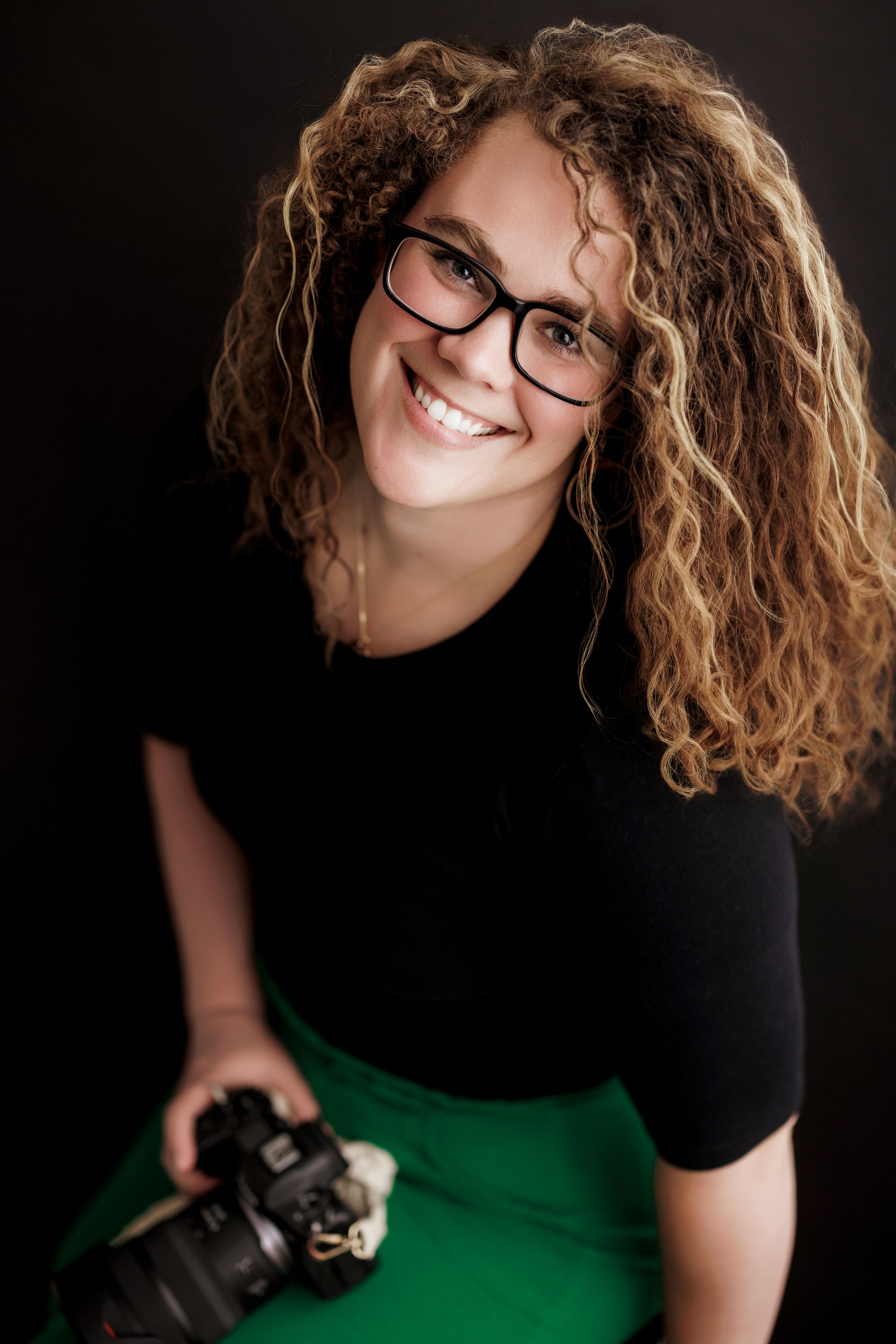Professional portrait series showing a photographer in black and green holding a camera against dark background.