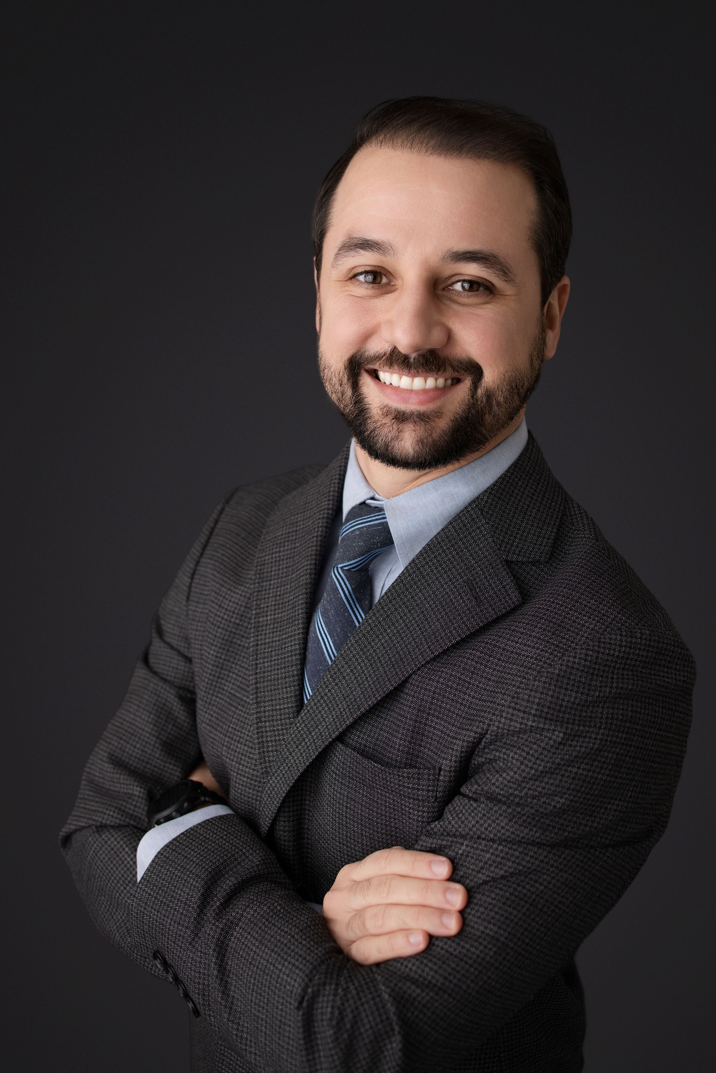 Professional portrait series showing a businessman in a gray suit against dark background with warm expressions.