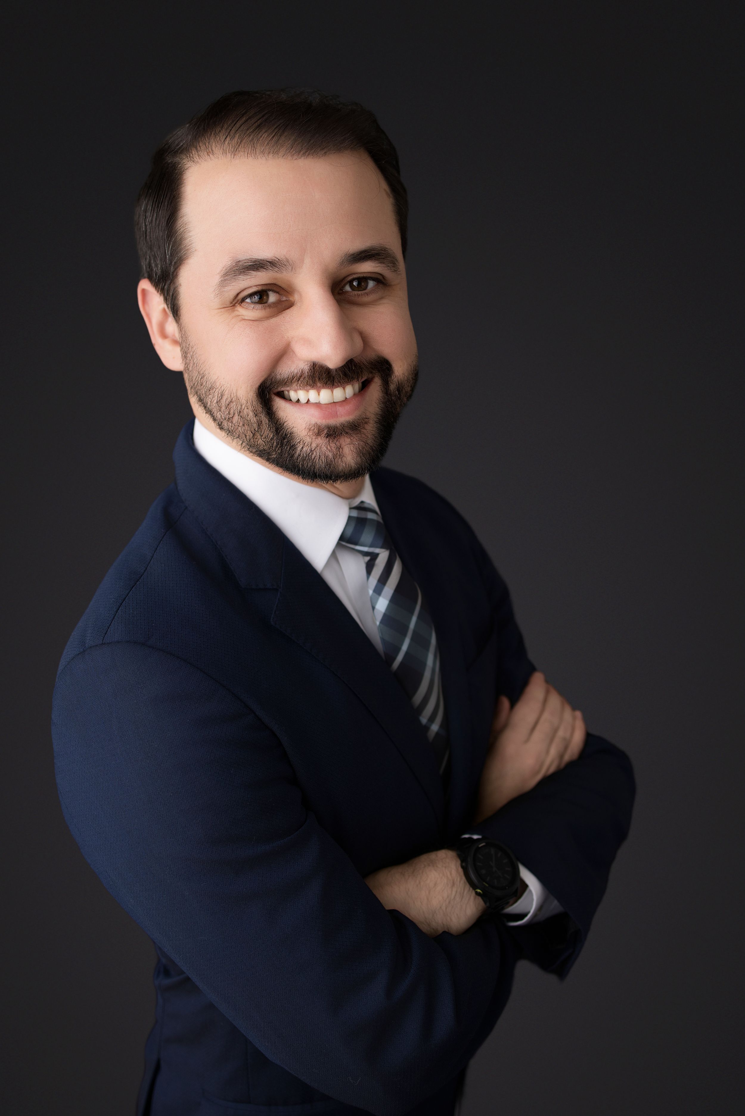 Business portrait series featuring a professional in a navy suit against dark backdrop with confident poses.