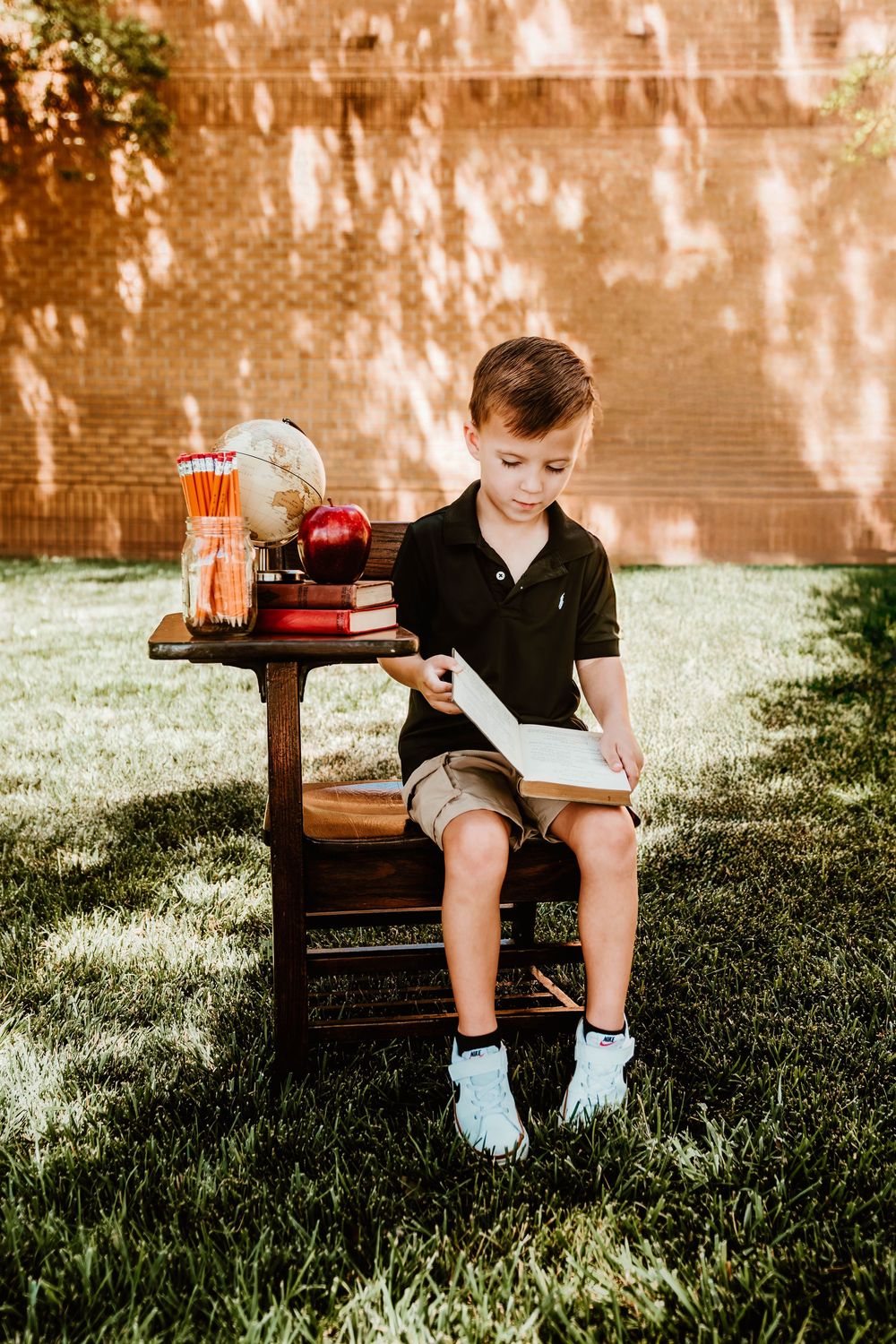A rustic outdoor scene with vintage books and school supplies on a wooden chair.