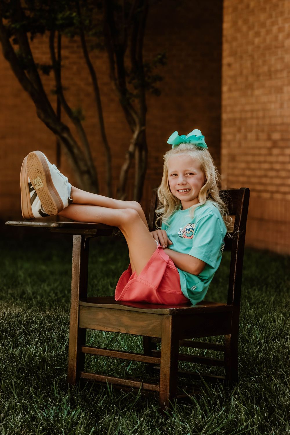 Turquoise and coral colored back-to-school scene with wooden chair and props.