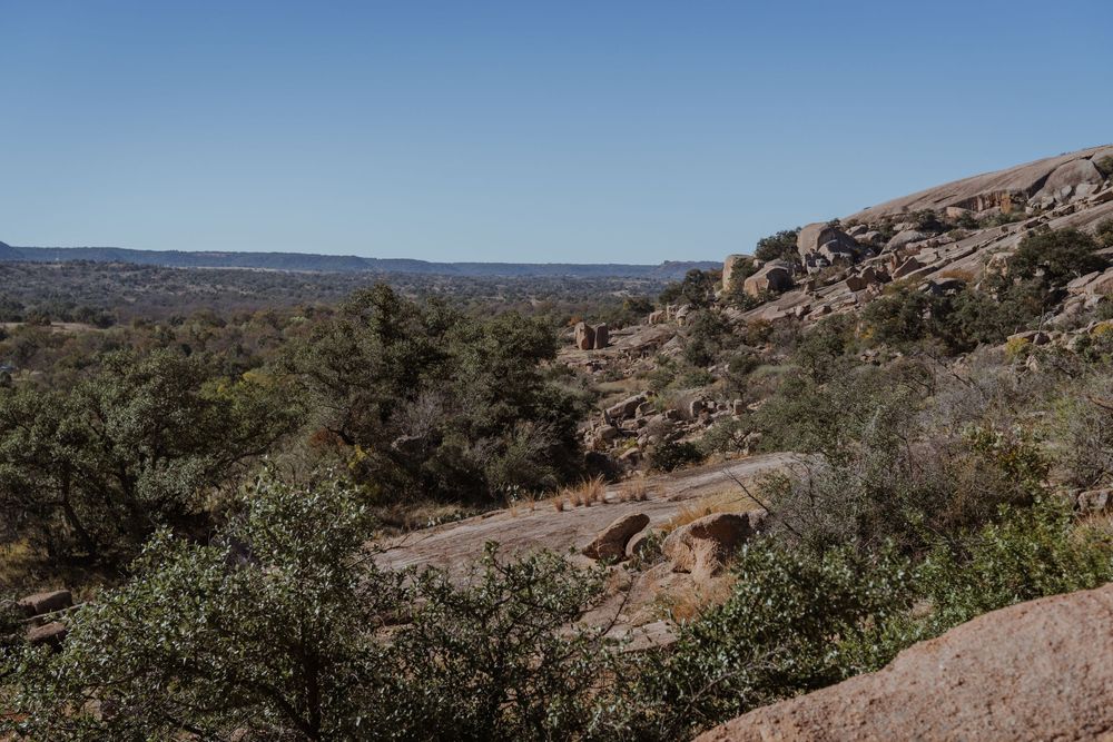 Panoramic view of rugged desert mountains with scrubland vegetation stretching across the horizon.