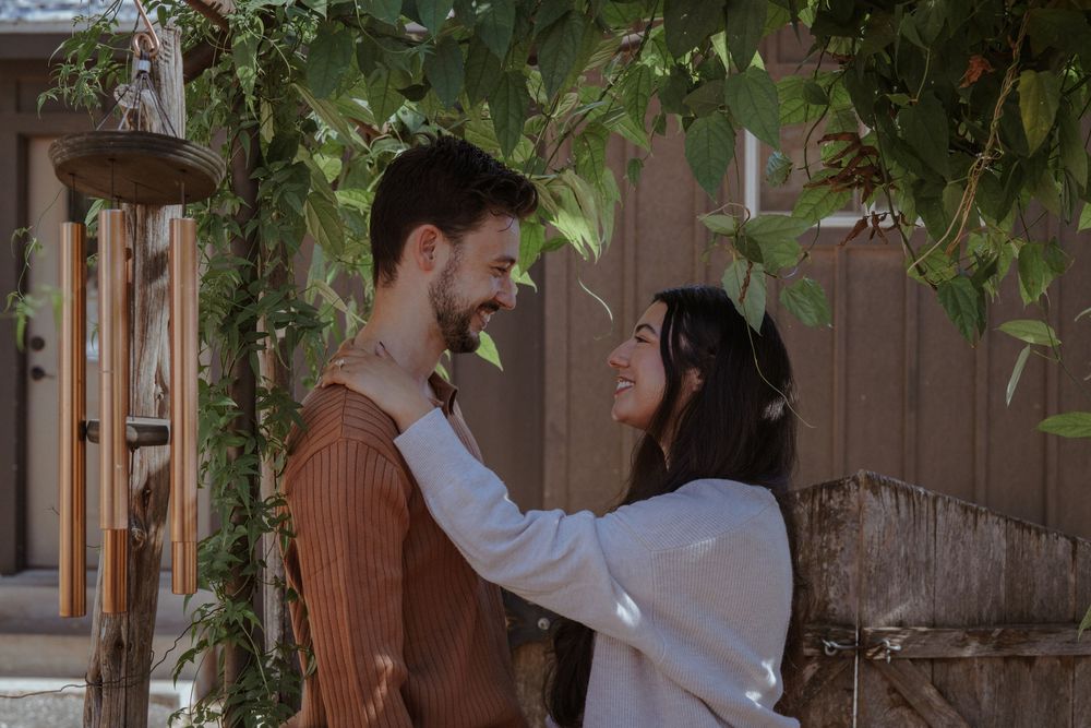 A couple dances together under hanging greenery in an intimate wedding setting.