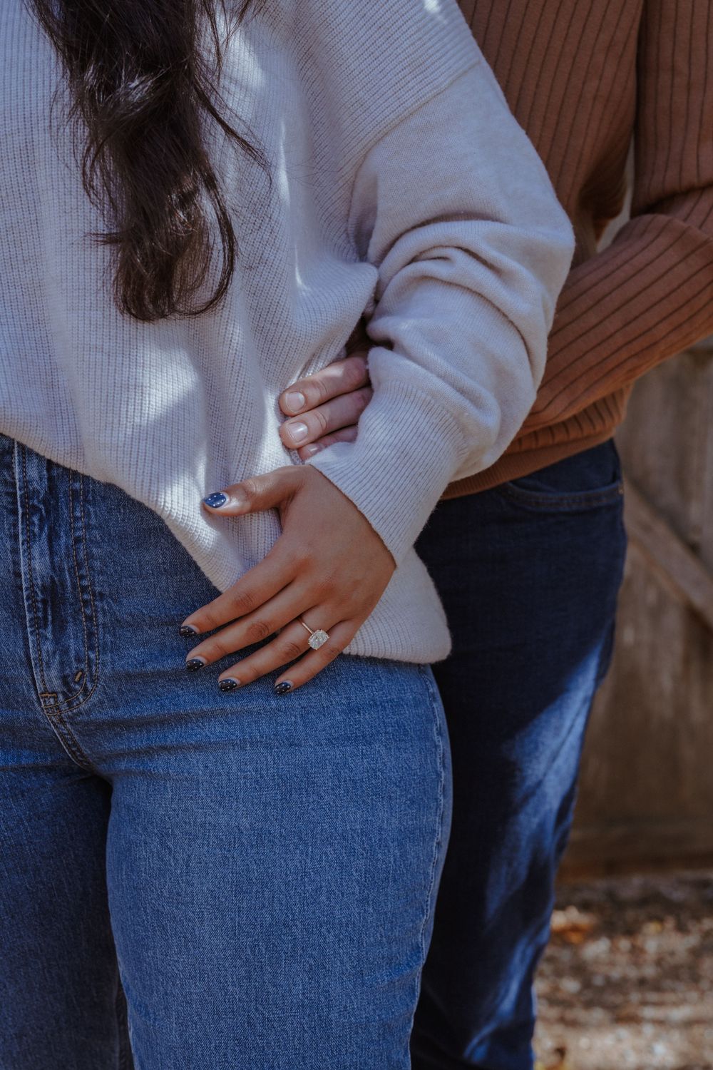 Close-up series showing someone wearing blue jeans and cream sweater with hands on hip in natural lighting.