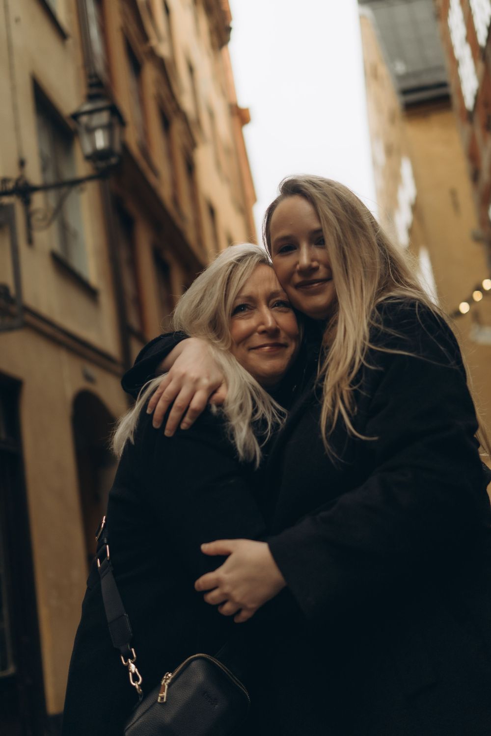 mom and daughter hugging during vacation photoshoot in Stockholm in December while being captured by best family photographer in Stockholm