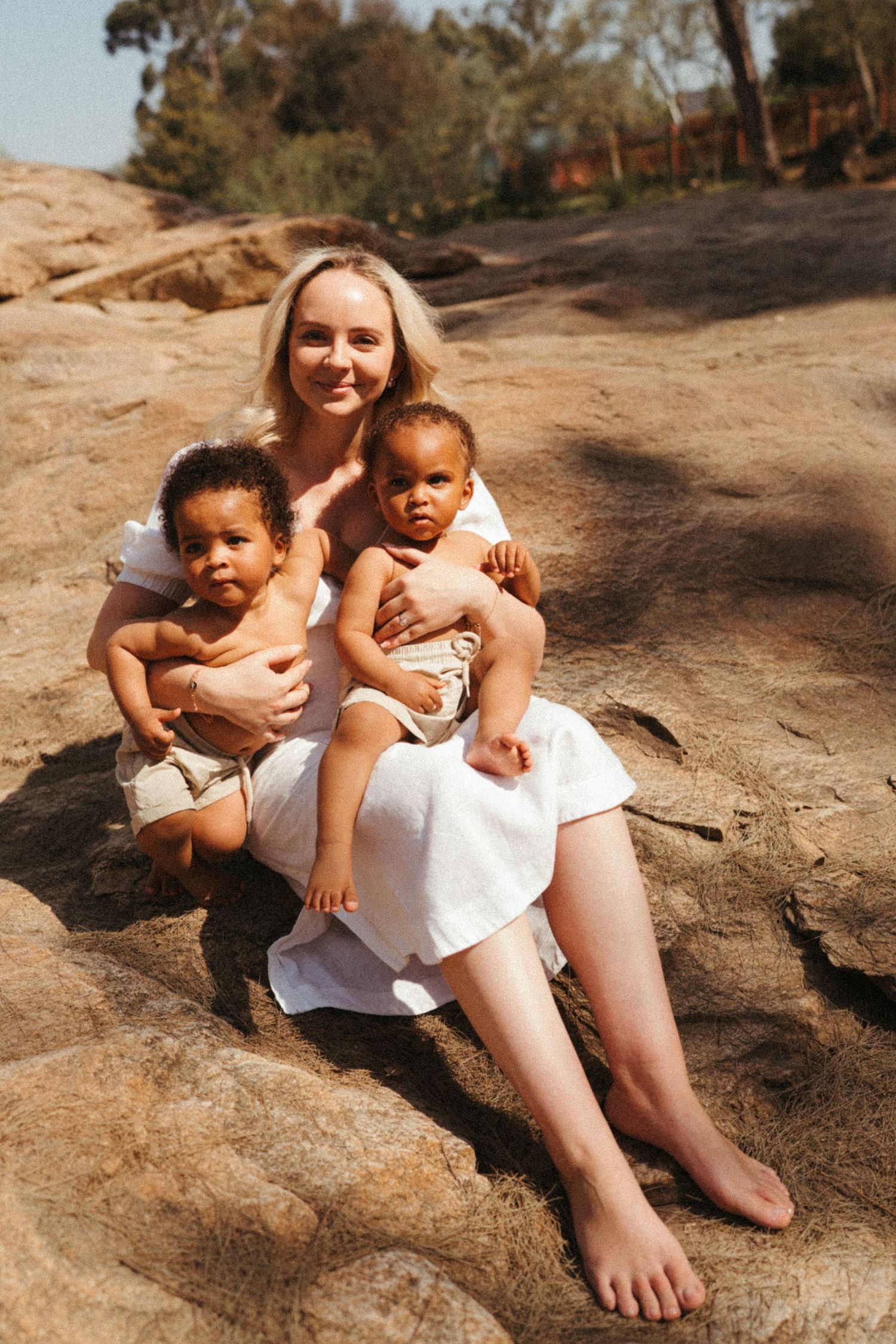Candid moments captured of people sitting together on sun-warmed rocks outdoors.