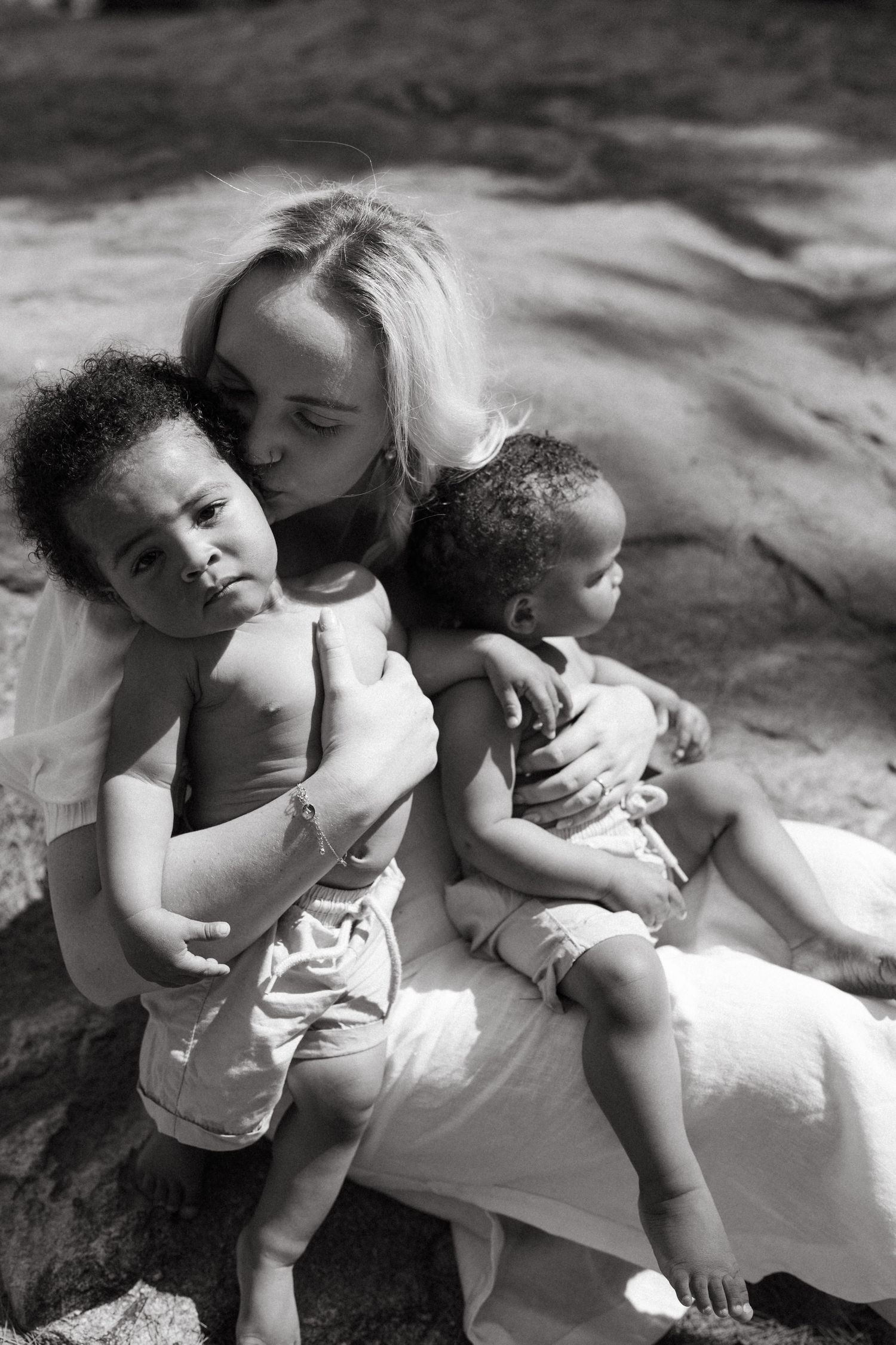 Black and white photo series capturing sweet moments of connection and closeness outdoors.