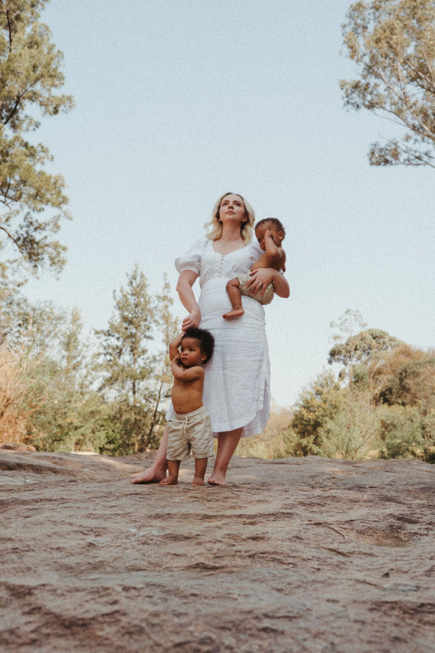 Scenic outdoor photoshoot on rocky terrain with trees in the background.