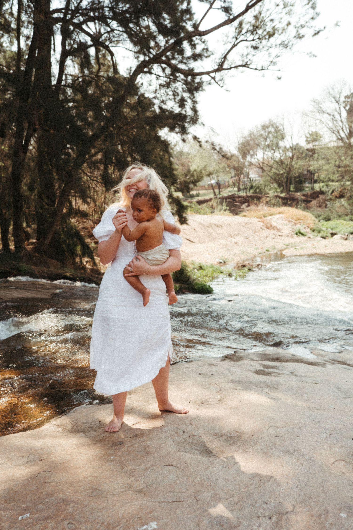 Sweet candid moments captured between caregiver and child playing outdoors in natural lighting.