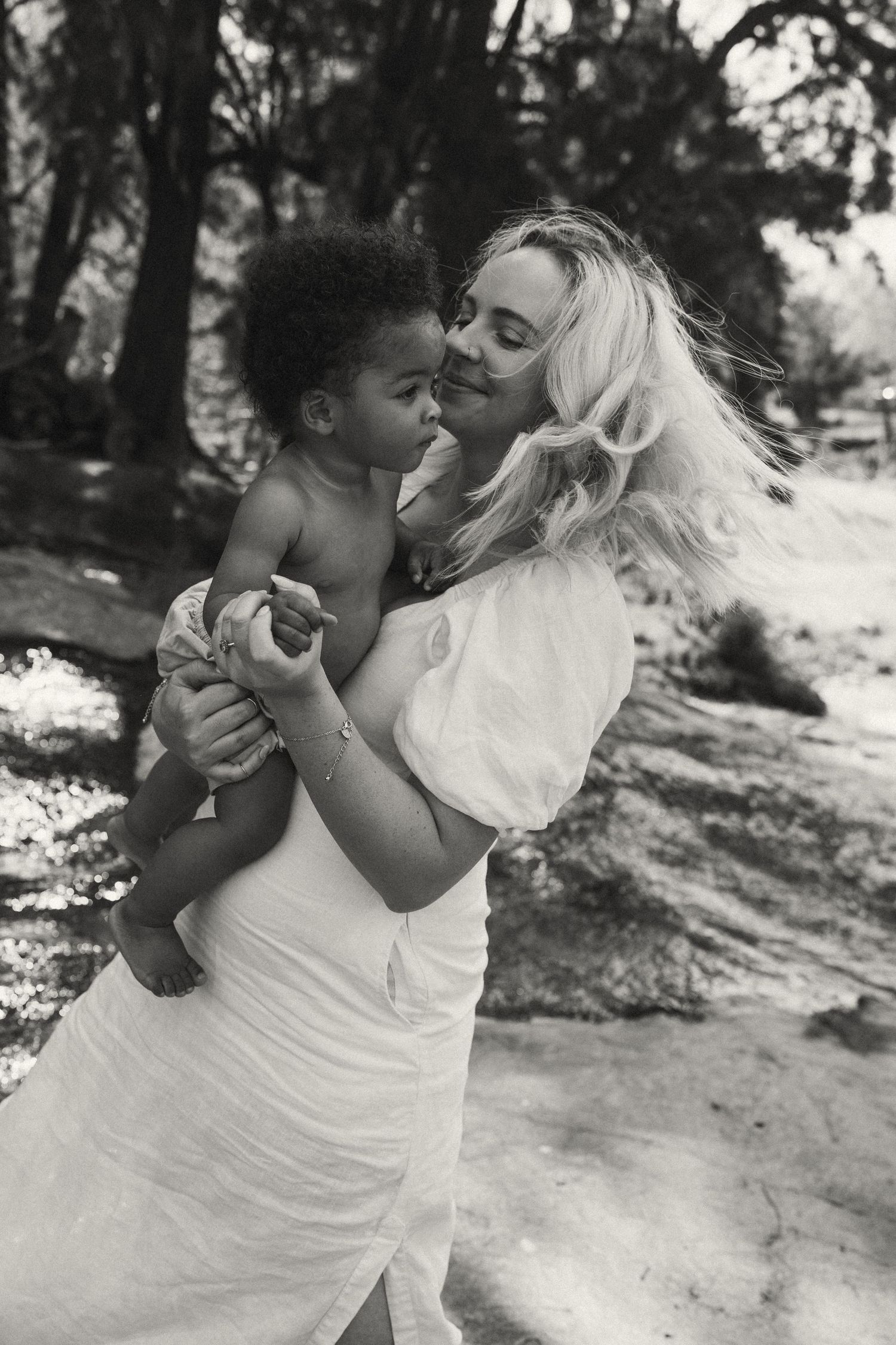 Black and white series showing loving embrace between adult and child outdoors.