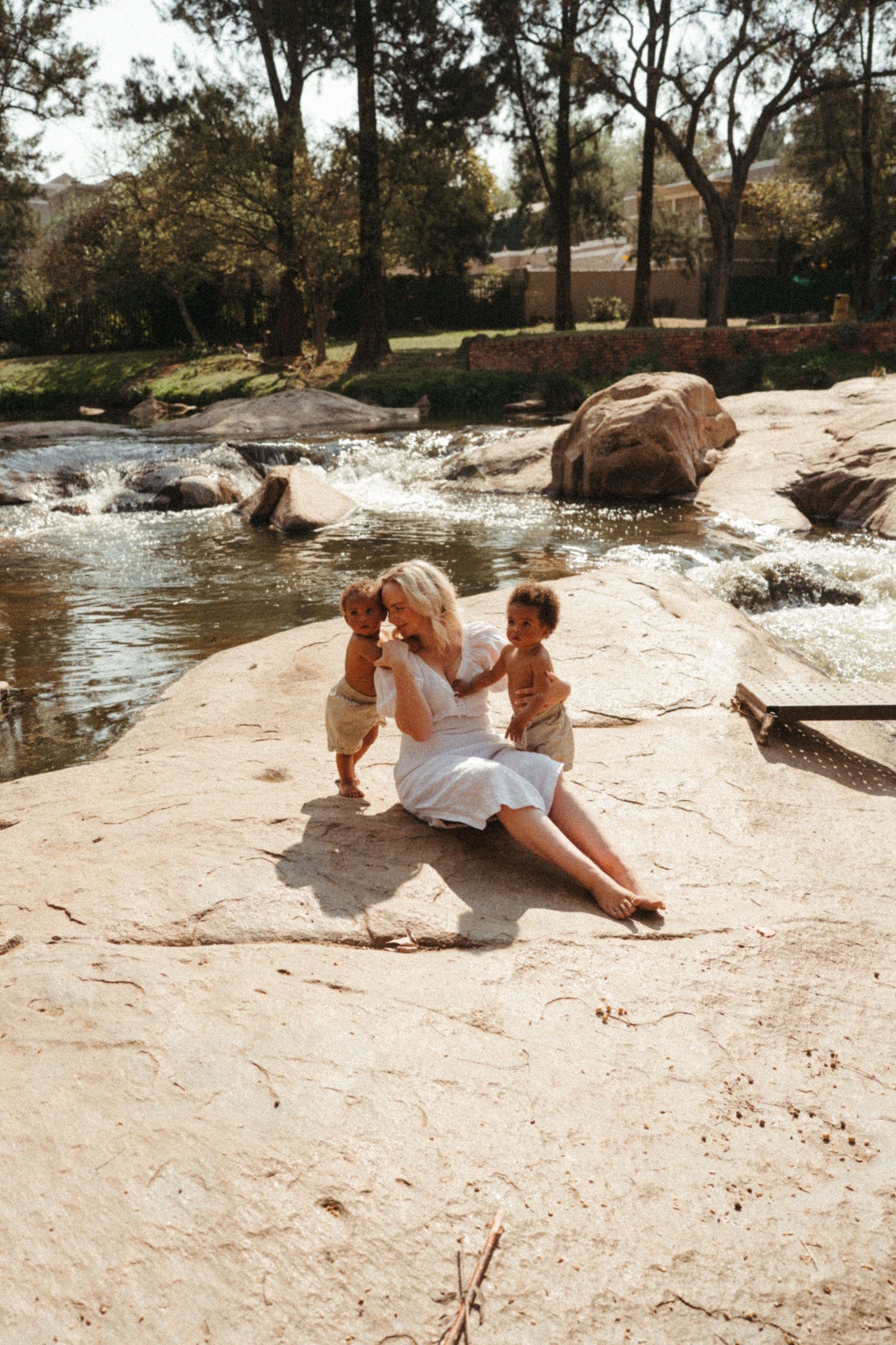 Playful moments captured on rocky terrain beside a flowing stream.