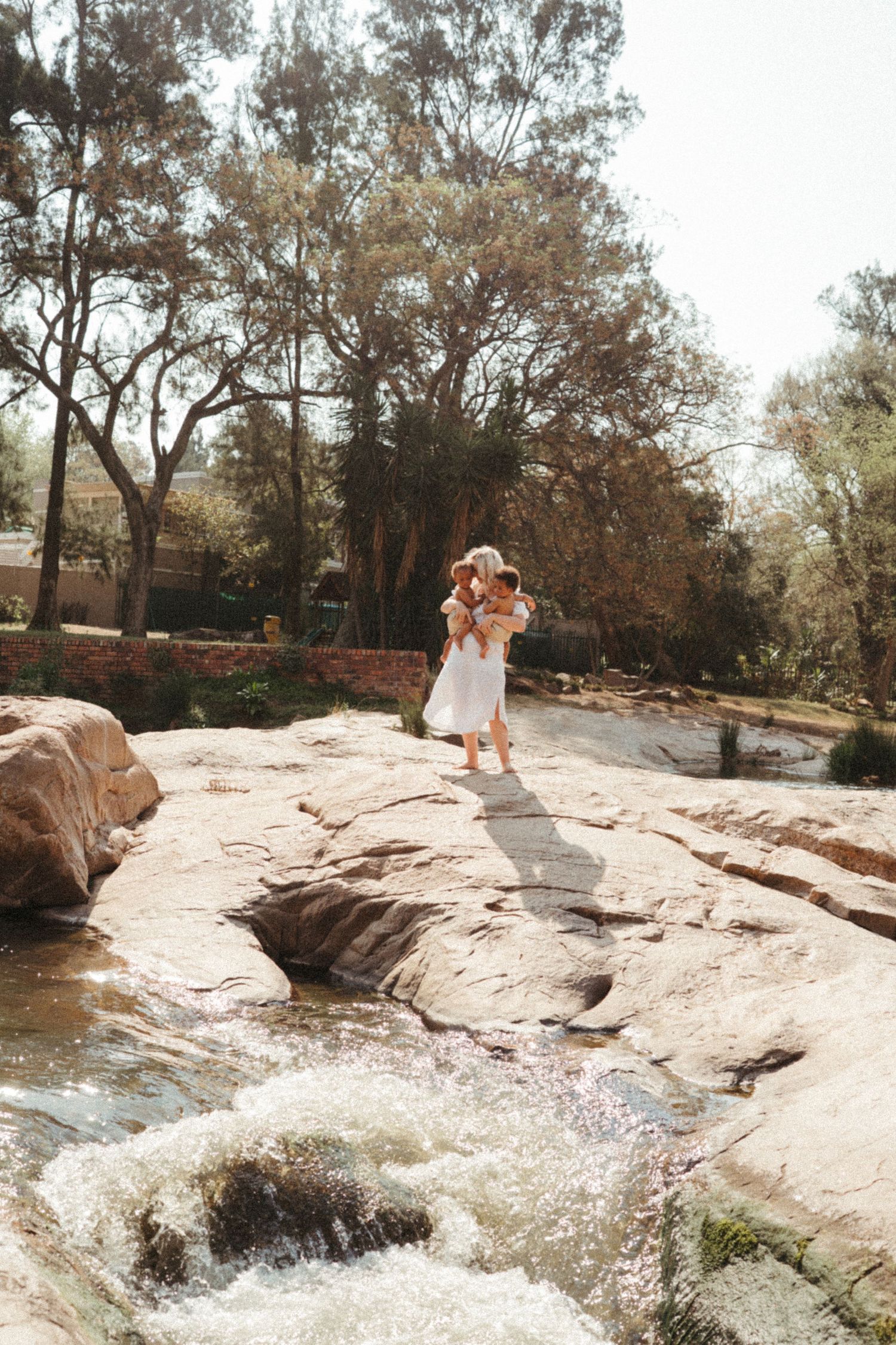 Scenic outdoor photoshoot near a flowing stream with rock formations.