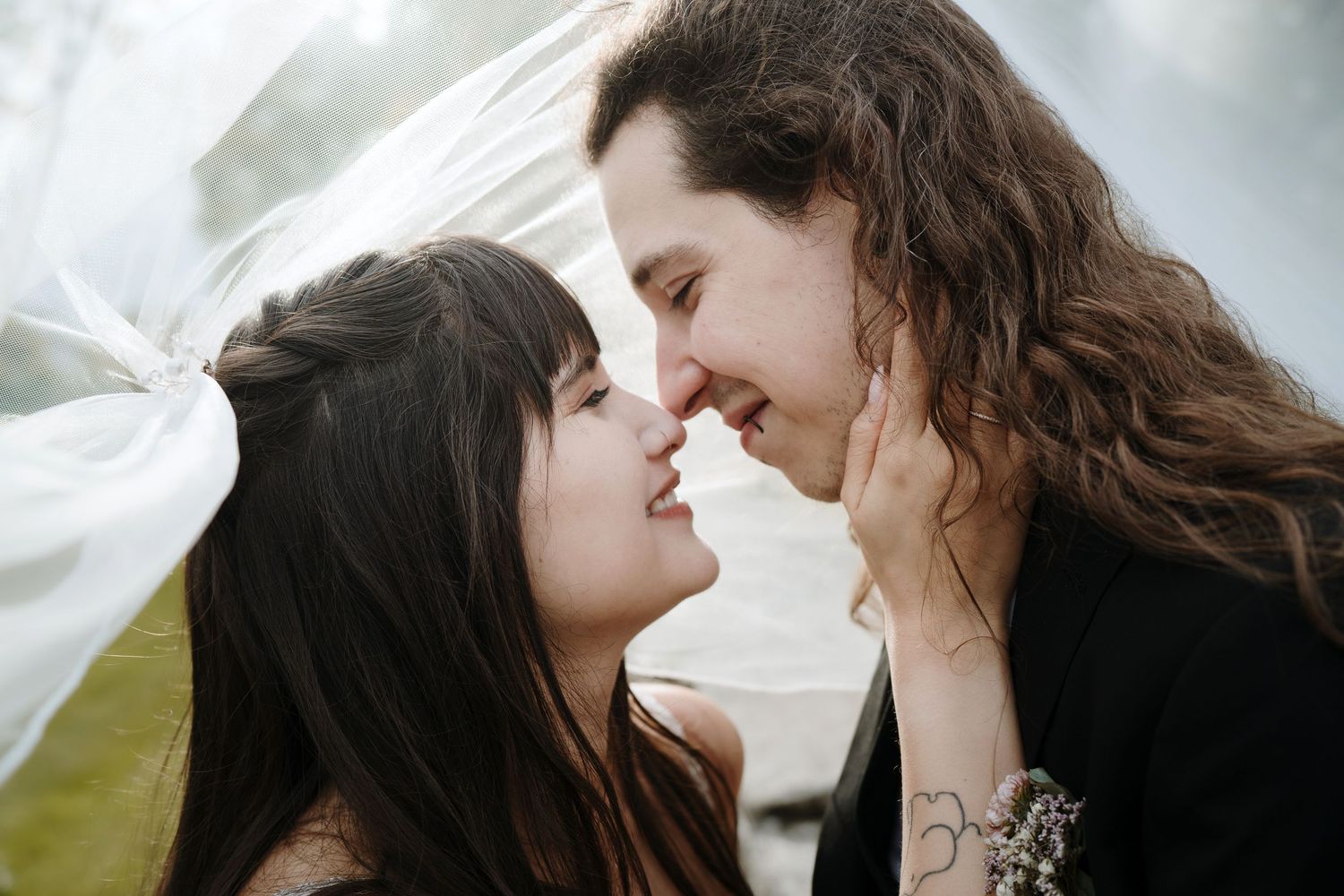 A couple shares romantic moments in a scenic fall setting during their outdoor wedding photo session.