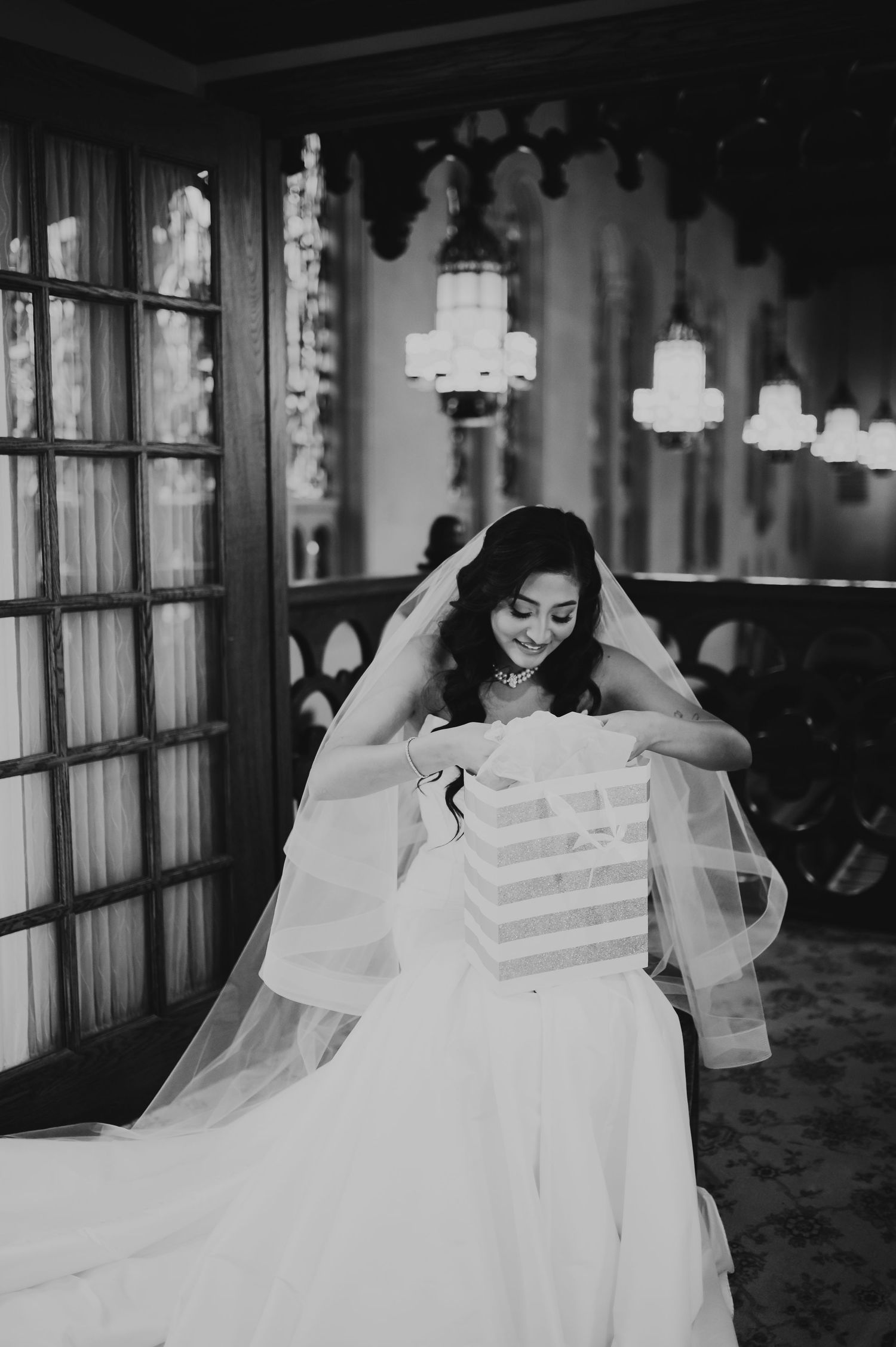 A black and white photo series showing a bride in a flowing veil during wedding preparations.