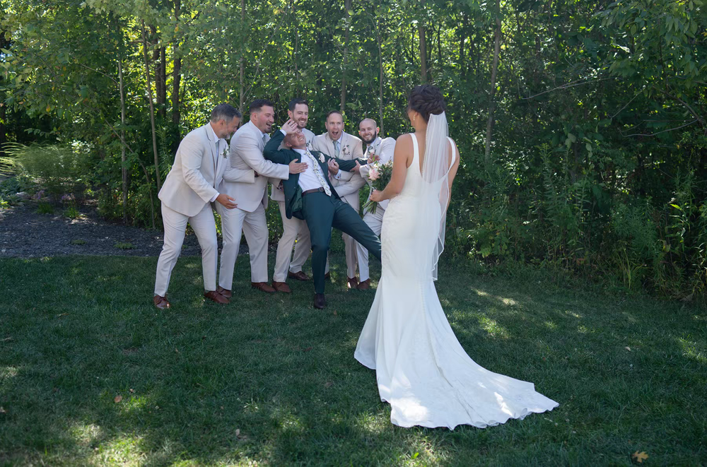 Wedding party poses together for photos in a lush green outdoor forest setting in ohio columbus venue