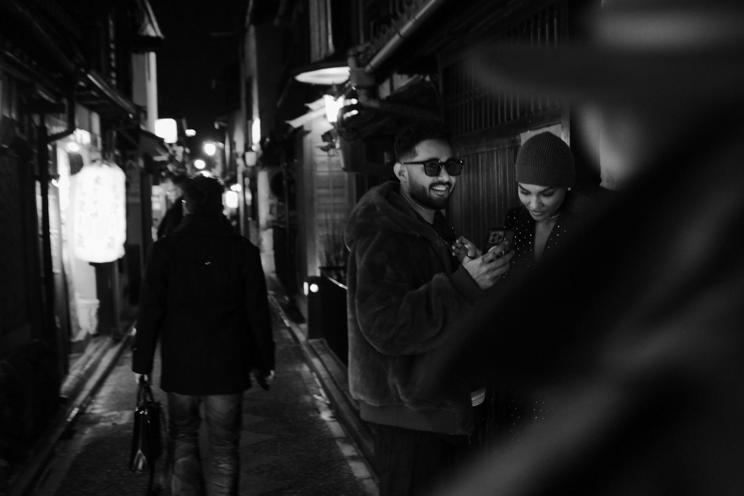Dimly lit narrow alleyways in Japan at night with glowing signs and street lamps creating an atmospheric urban scene.