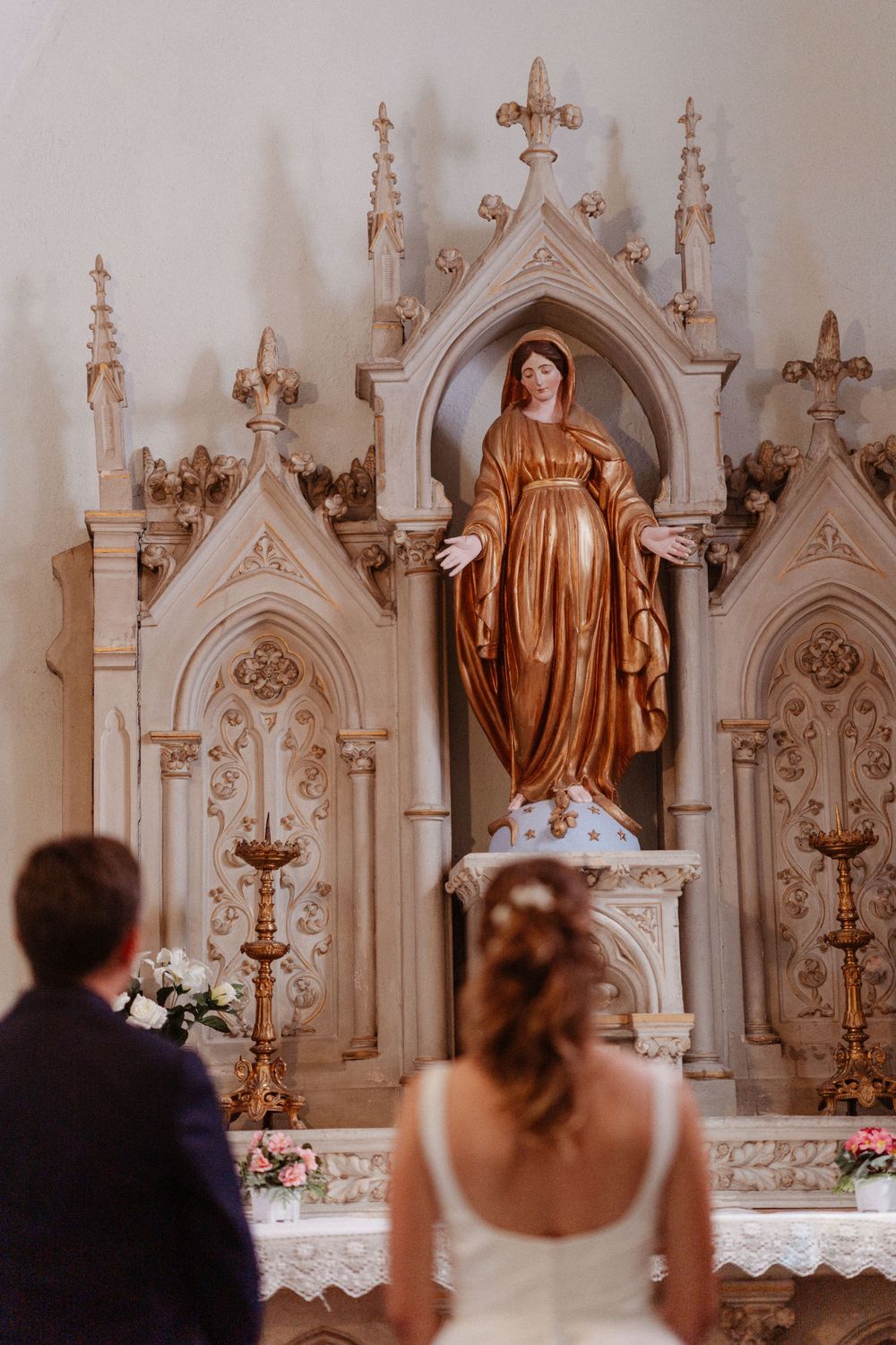 un couple de mariés devant la vierge Marie