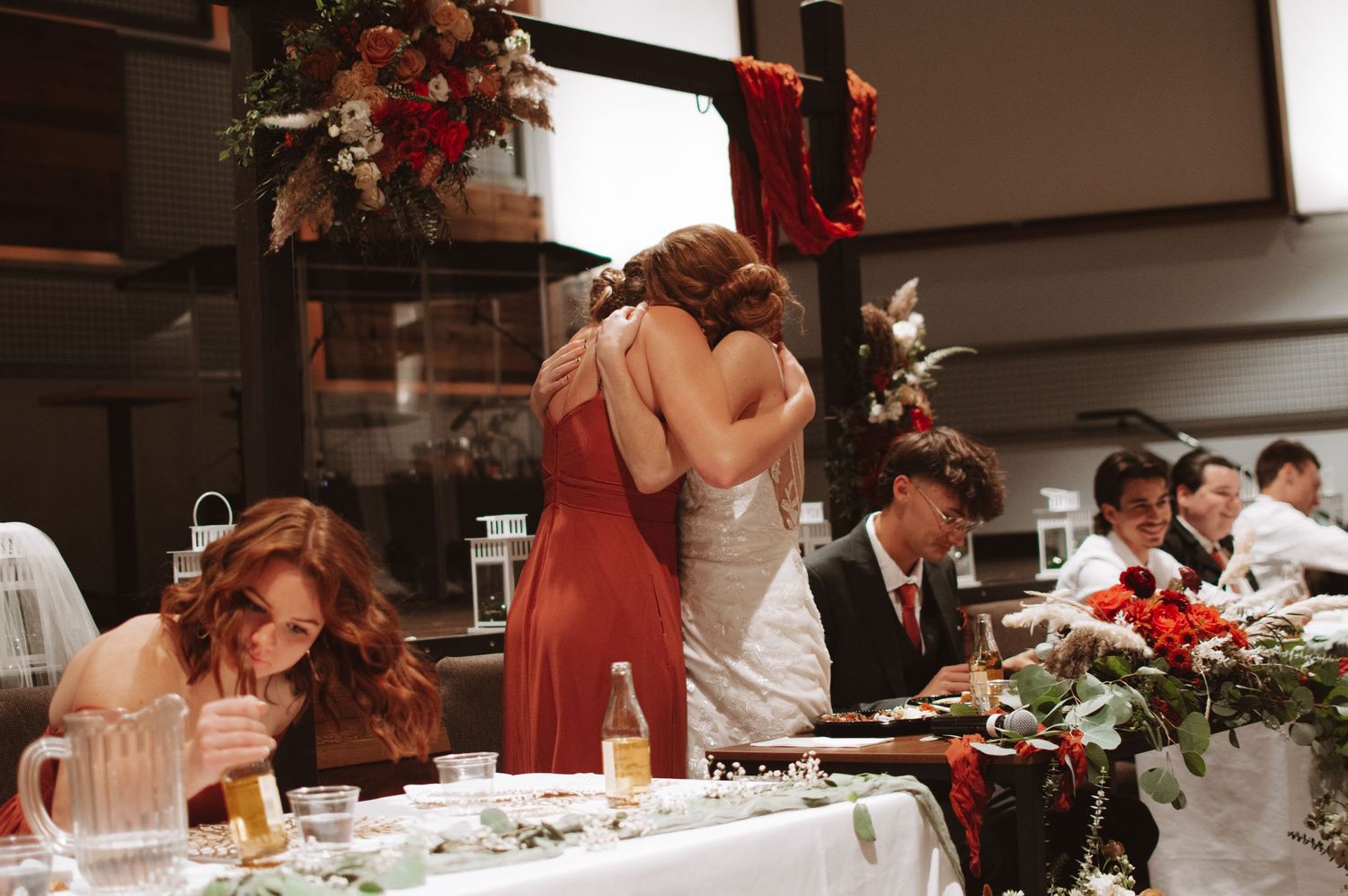 Wedding reception table decorated with floral arrangements and place settings.