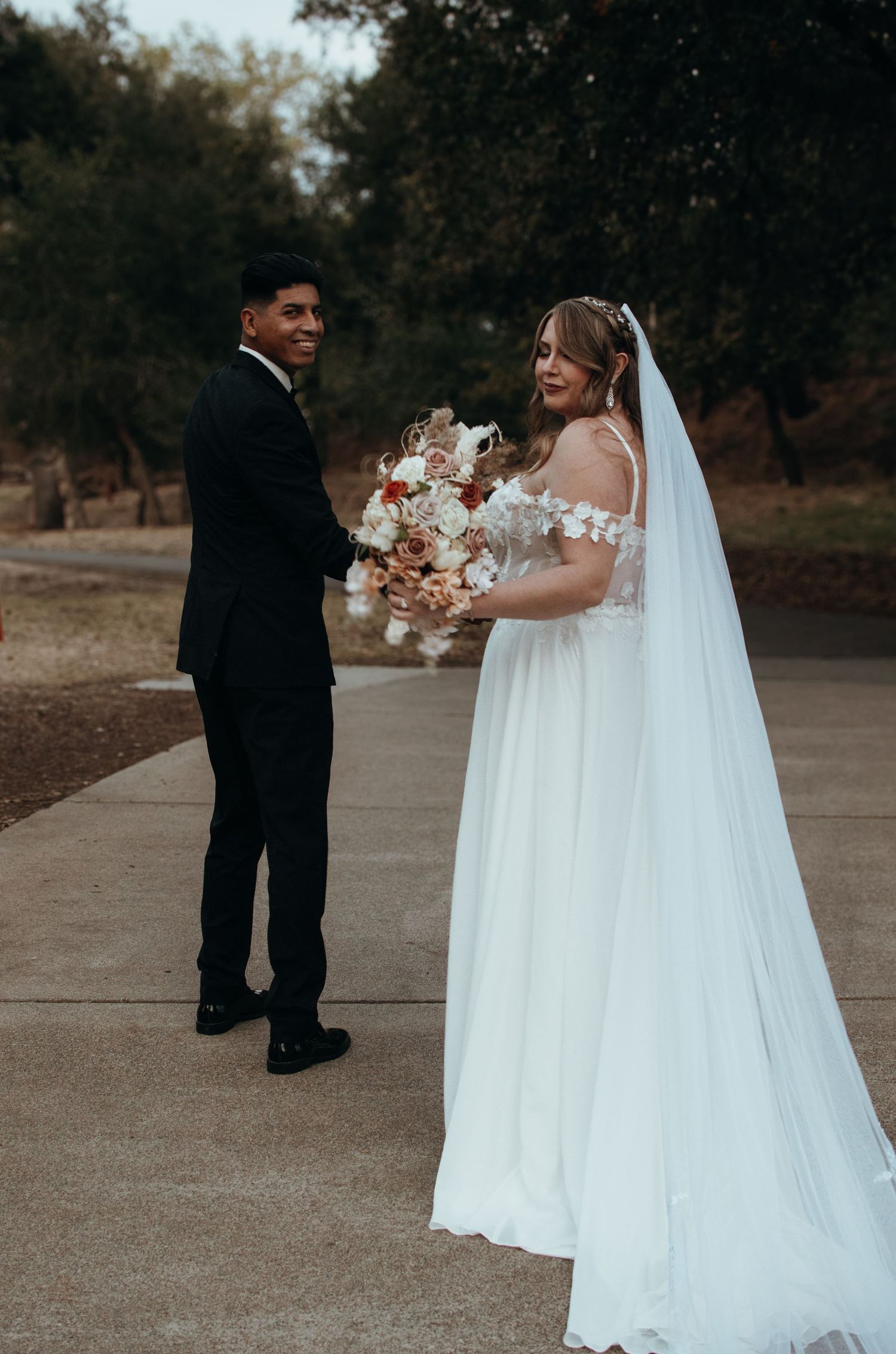 Full-length wedding portraits in an outdoor setting with flowing white dress.