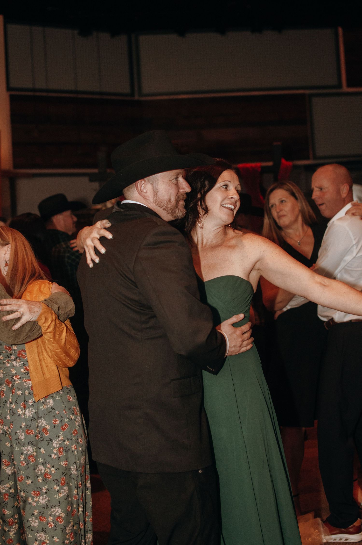Wedding reception dance scene with guests in festive attire.