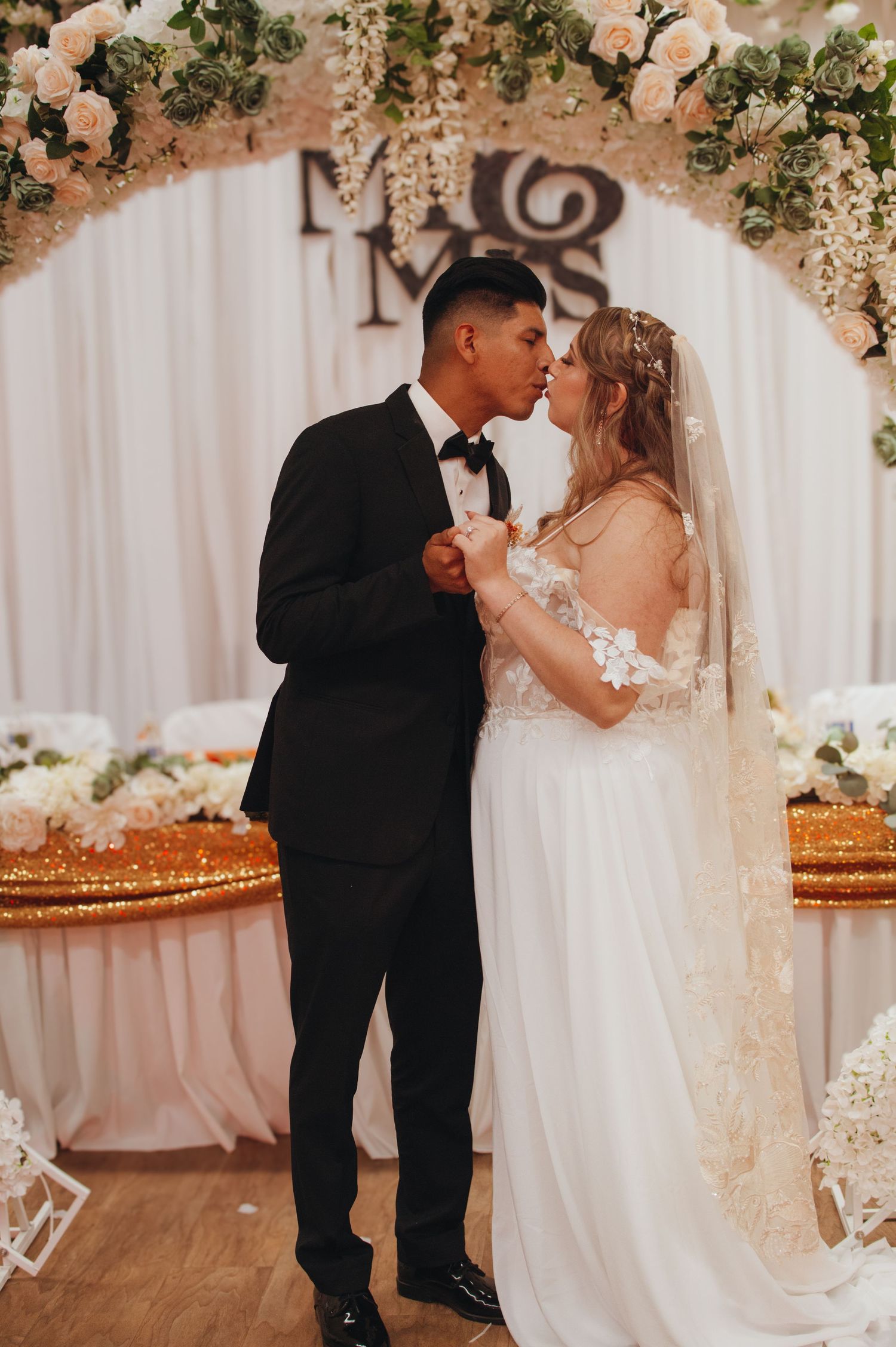 Couple dancing together during an elegant wedding celebration adorned with floral arrangements.