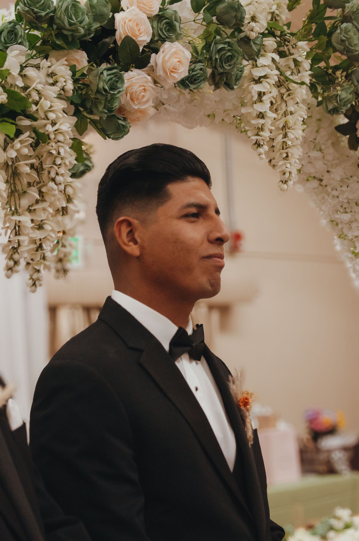 Wedding archway decorated with lush pink roses and cascading white floral arrangements.