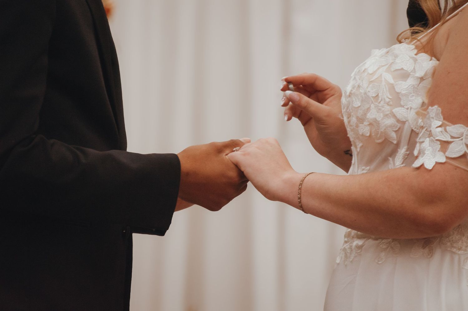 Close-up shot of hands exchanging wedding rings during a ceremony.