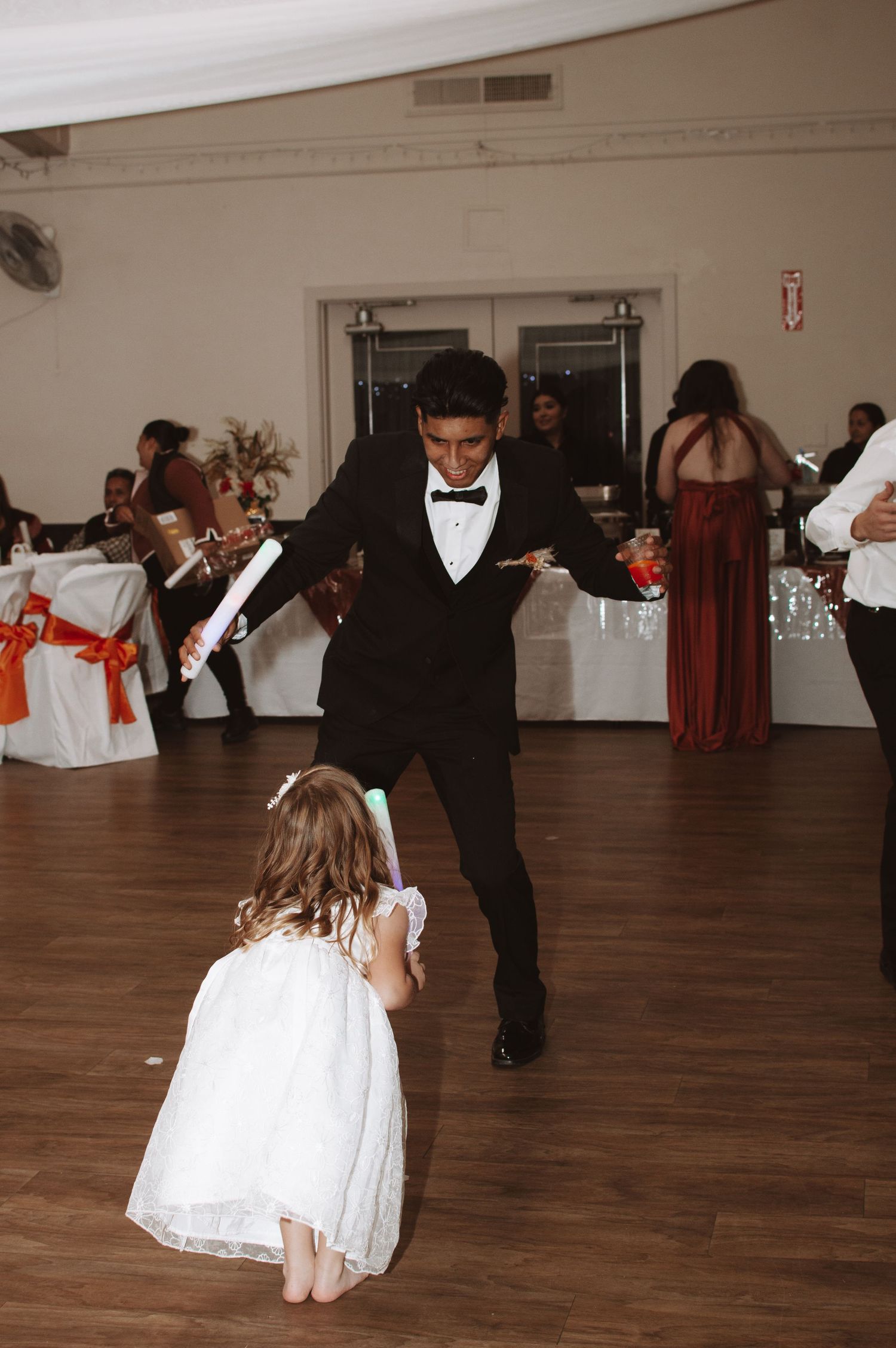 Dancers twirling on a wooden dance floor at an elegant wedding reception.