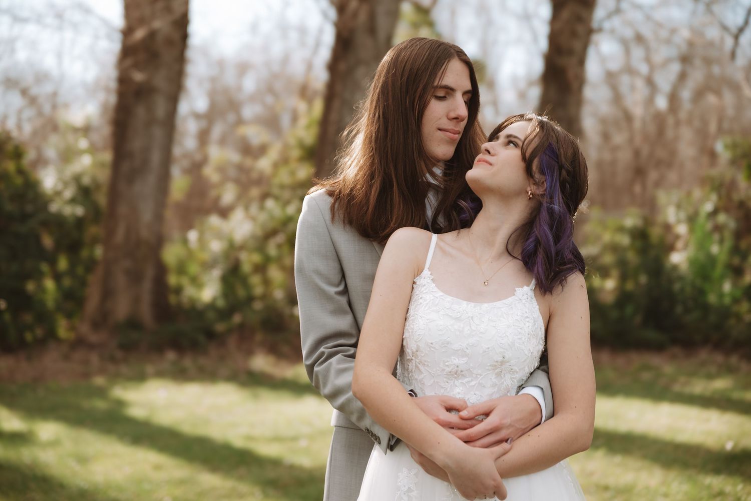 Tender moment between couple against natural winter forest backdrop.