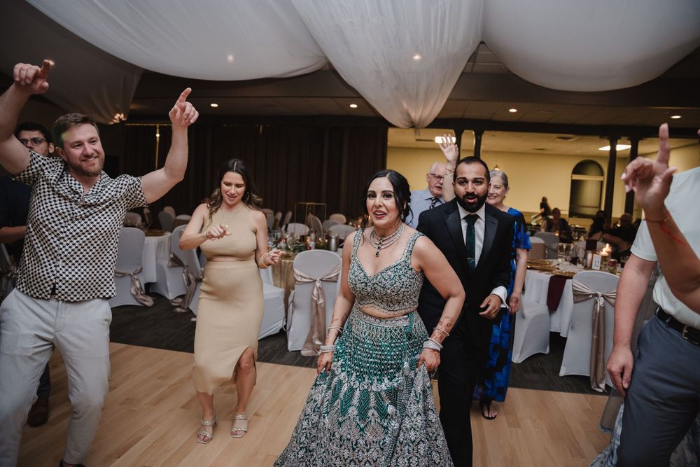 Wedding guests dance and celebrate on the wooden dance floor during the reception.