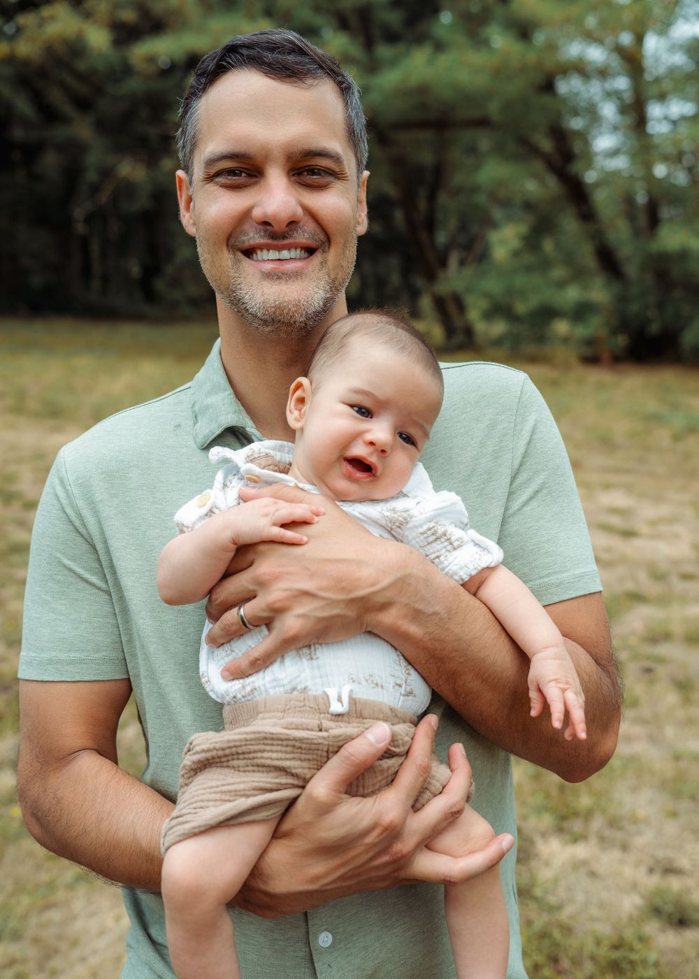Person holding a baby and showing playful expressions in a series of four connected outdoor photos.