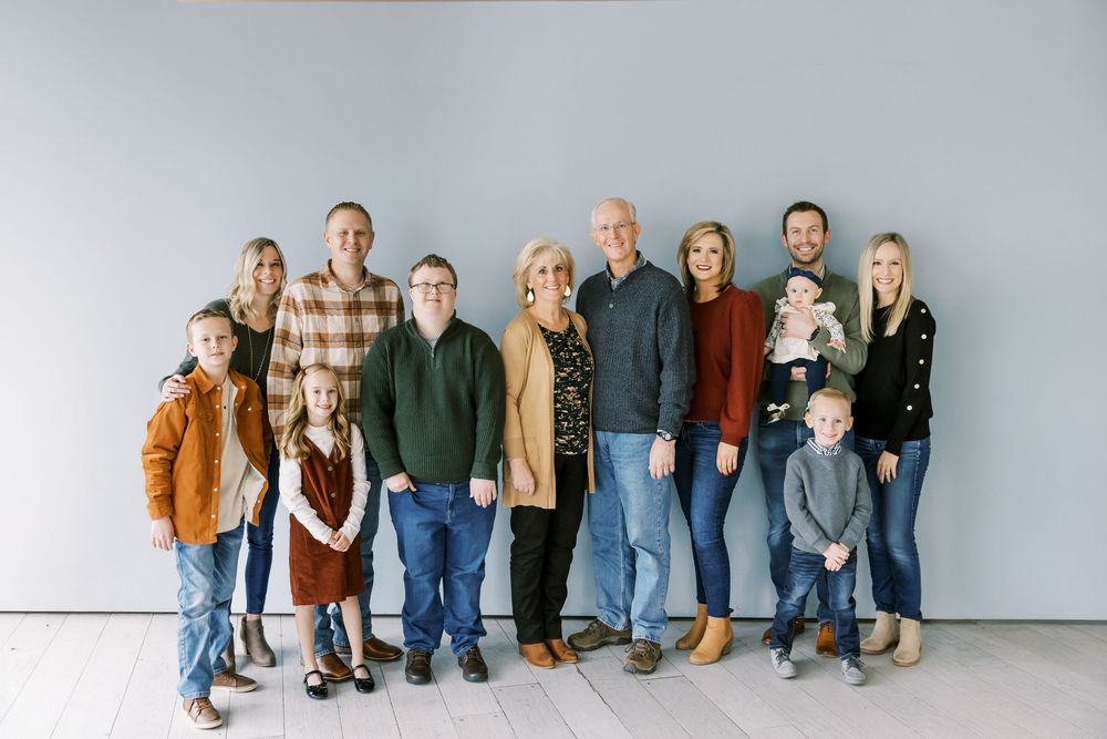 A group portrait posed against a light gray background with everyone wearing casual clothing.